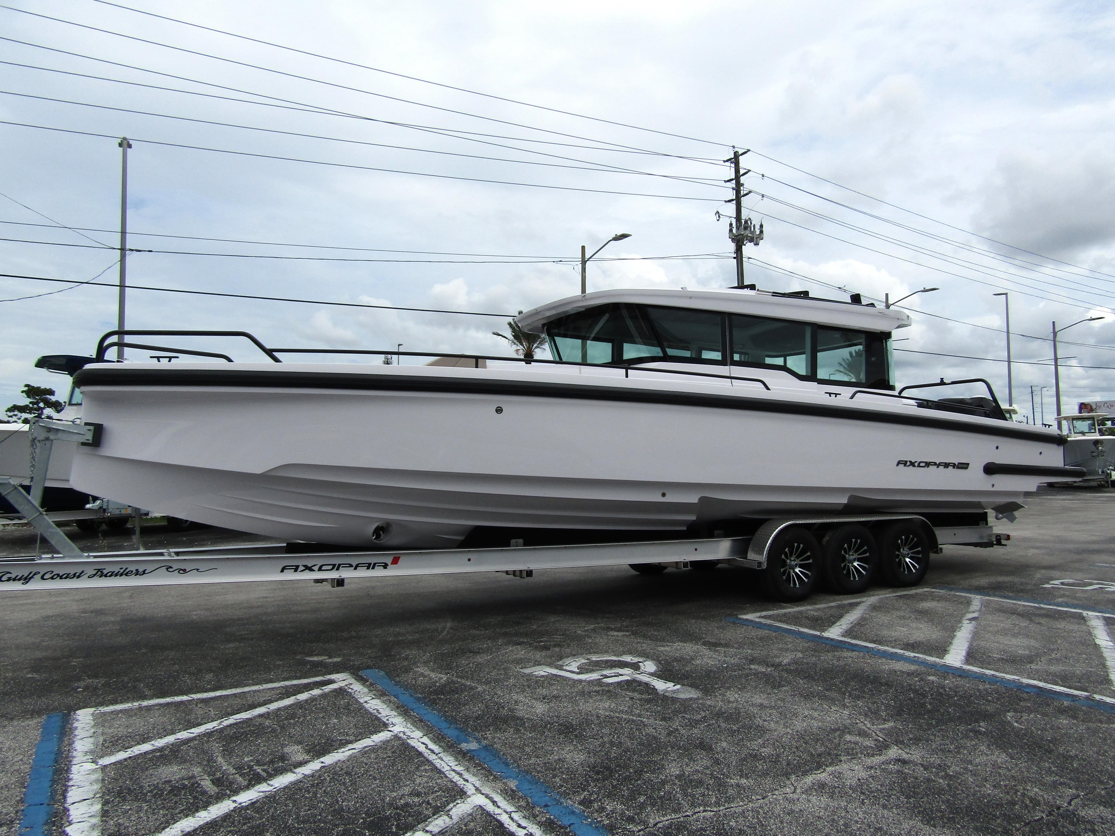 2024 Axopar 37XC CROSS CABIN boat on trailer in parking lot.