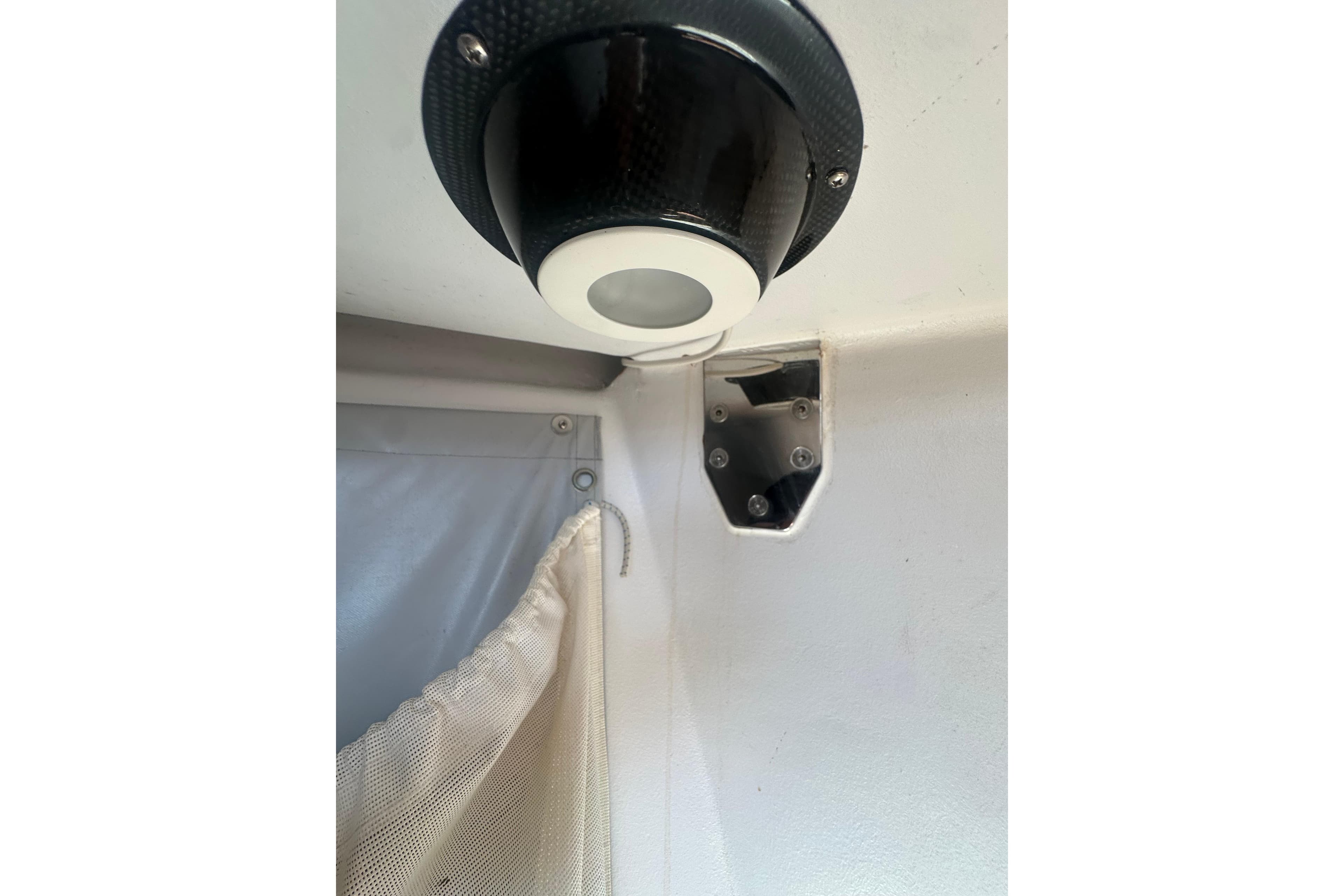 Interior detail of a 2006 Maxi Dolphin Cross Current 33 yacht, featuring a light fixture and curtain.