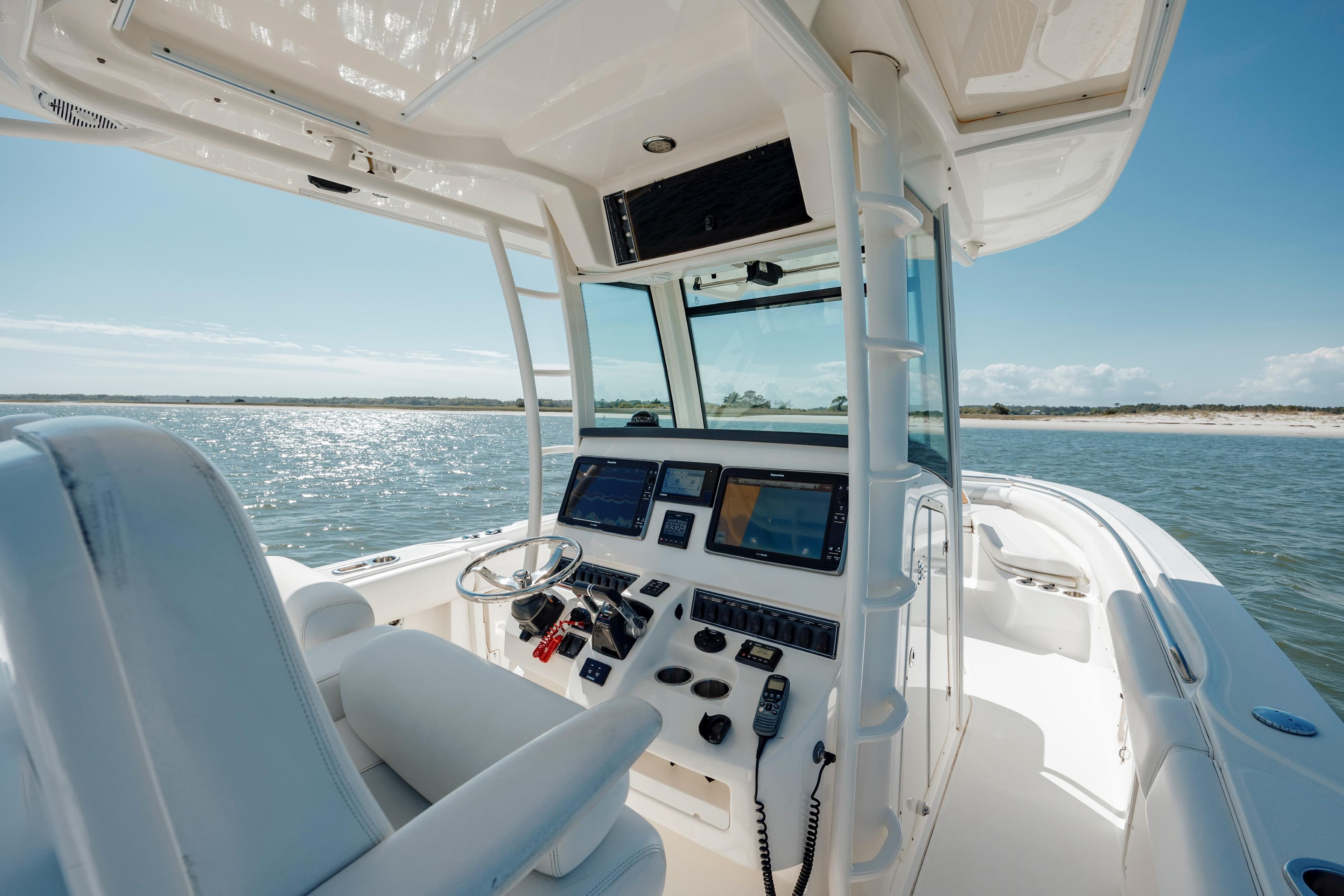2013 Boston Whaler 320 Outrage boat interior with modern navigation equipment on a sunny day.
