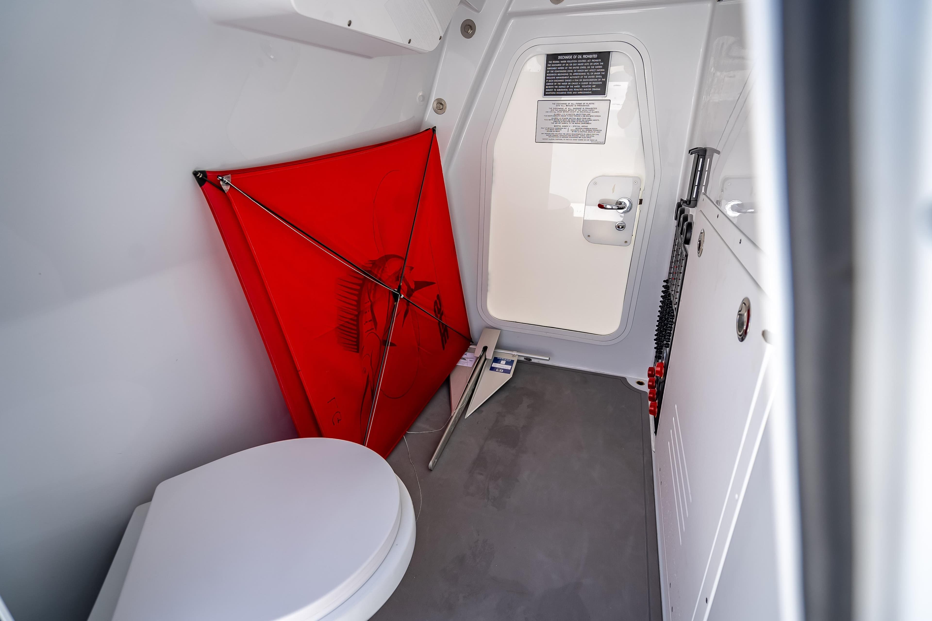 Interior of 2025 Freeman 43 boat with toilet, red kite, and storage area.
