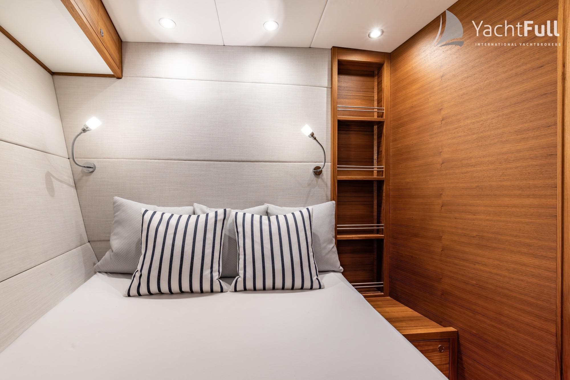 Luxurious cabin interior of 2024 RSC 1900 yacht with striped pillows and wooden accents.