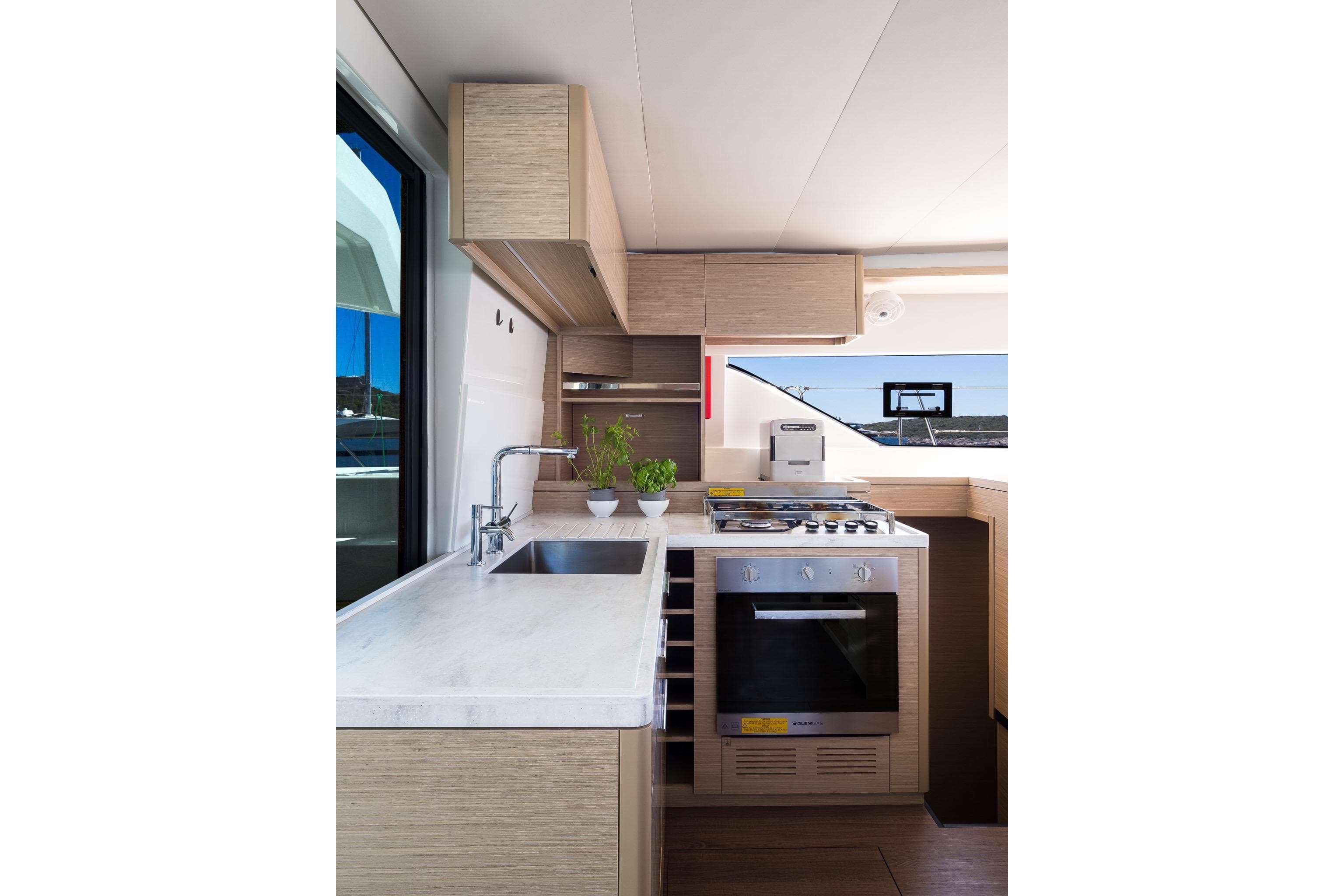 Modern kitchen interior of 2023 Lagoon LAGOON 51 yacht with sleek design and appliances.