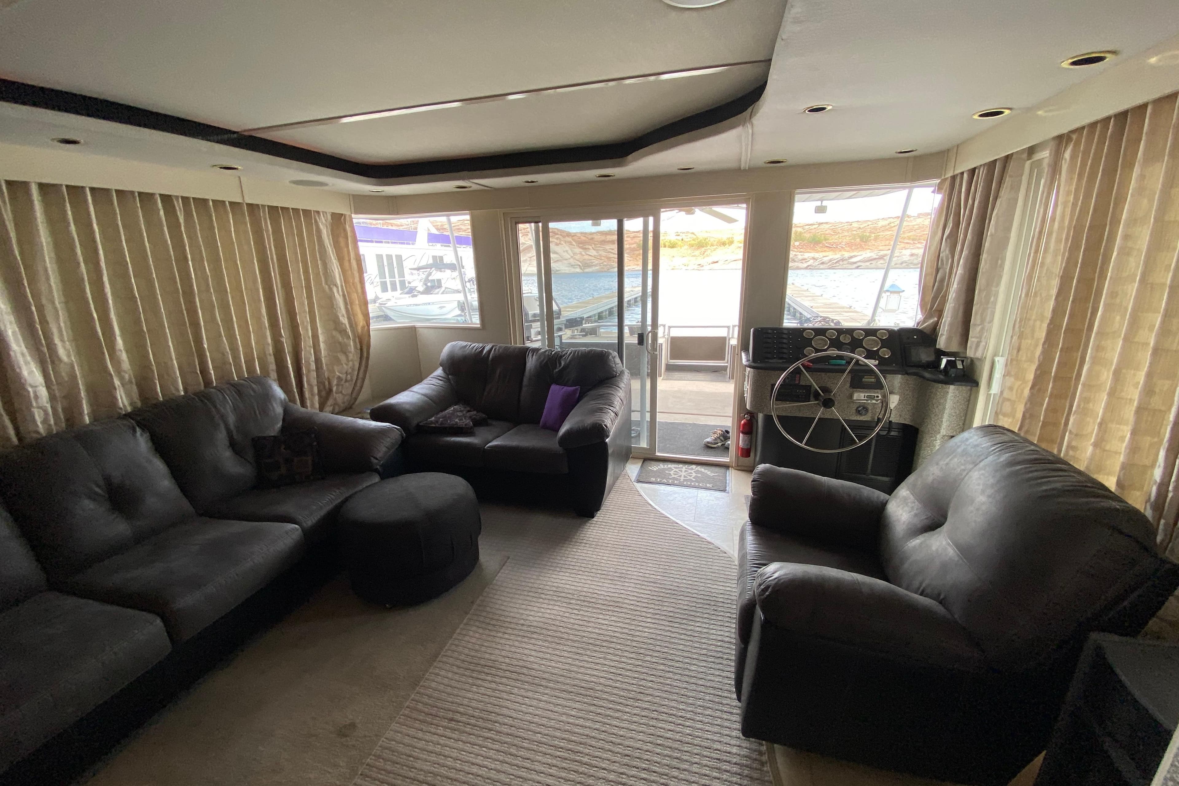 Luxurious 2000 Navigator Showboat interior with leather seating and helm, overlooking marina.