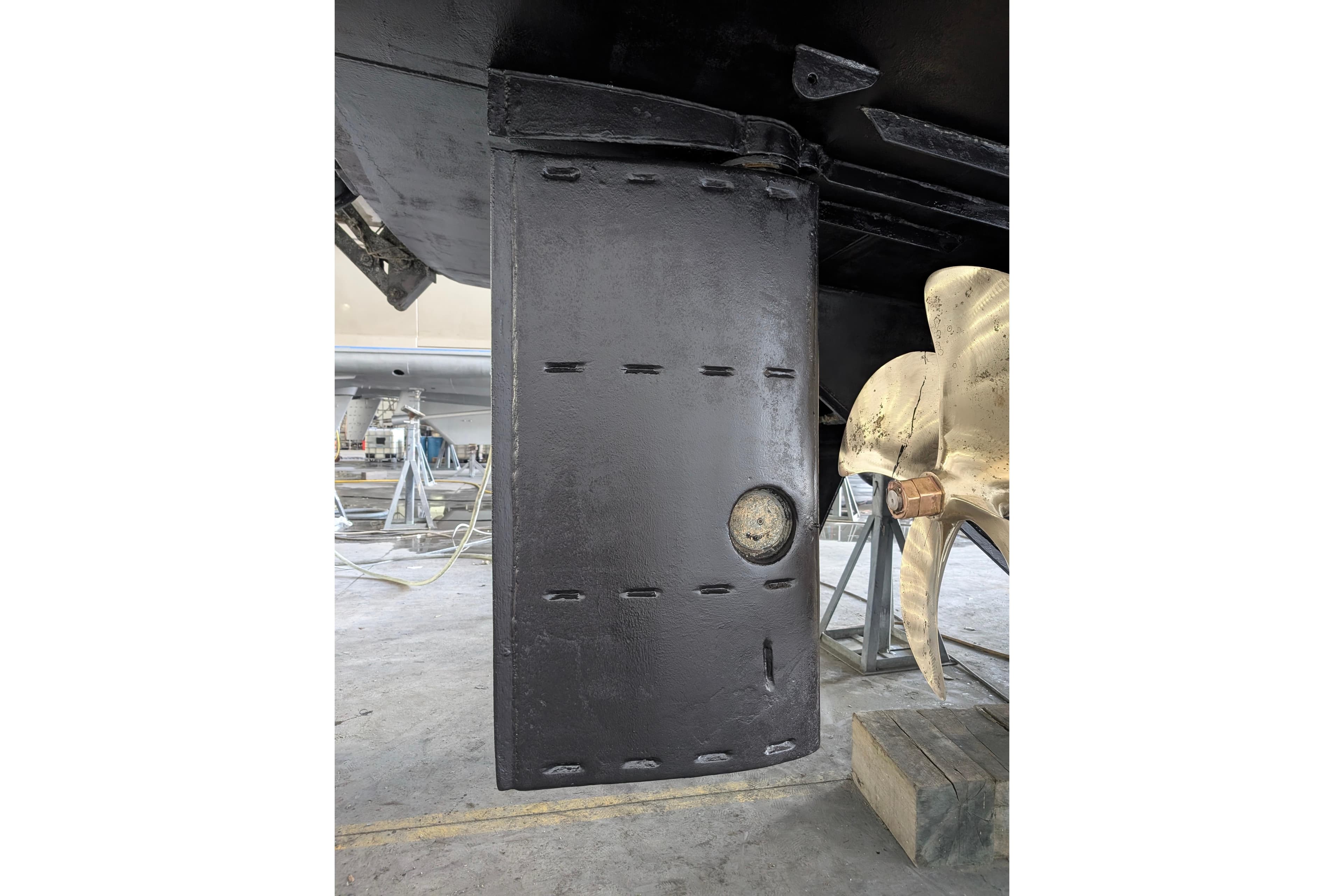 Close-up of a 2001 Doggersbank yacht rudder and propeller in a shipyard.