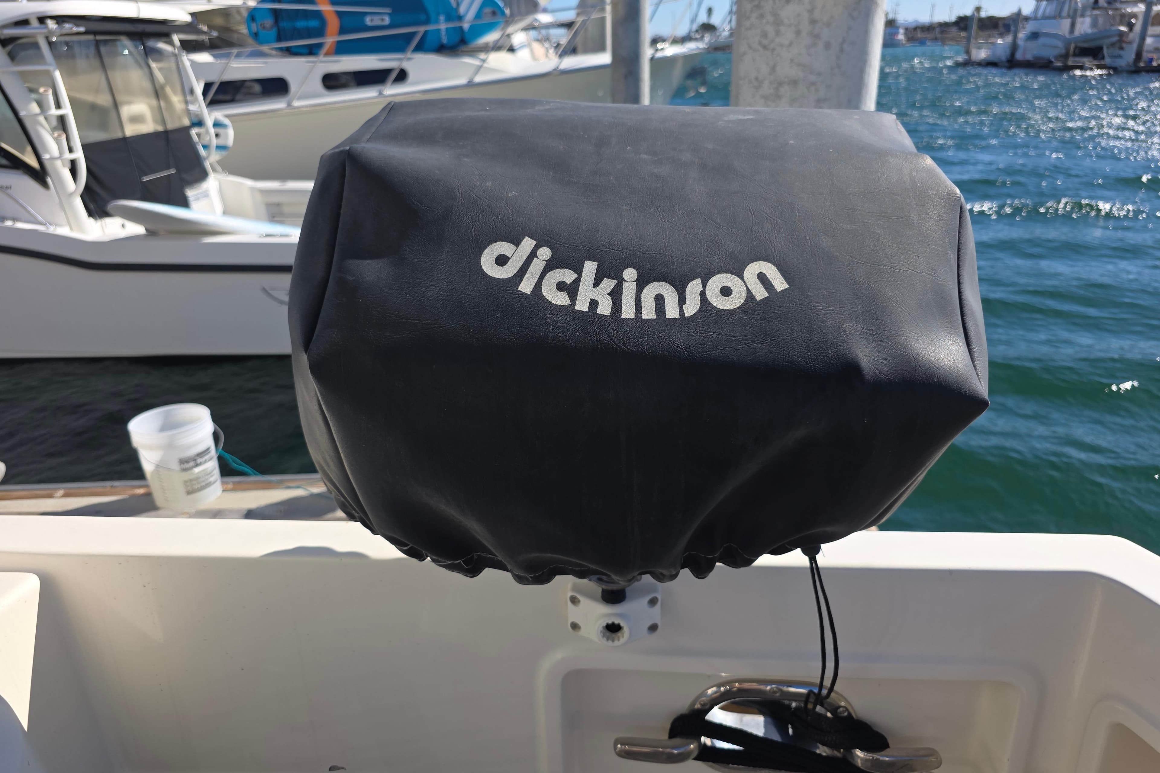 Cover on a McKinna 48 Pilothouse boat, featuring Dickinson branding, docked at a marina.