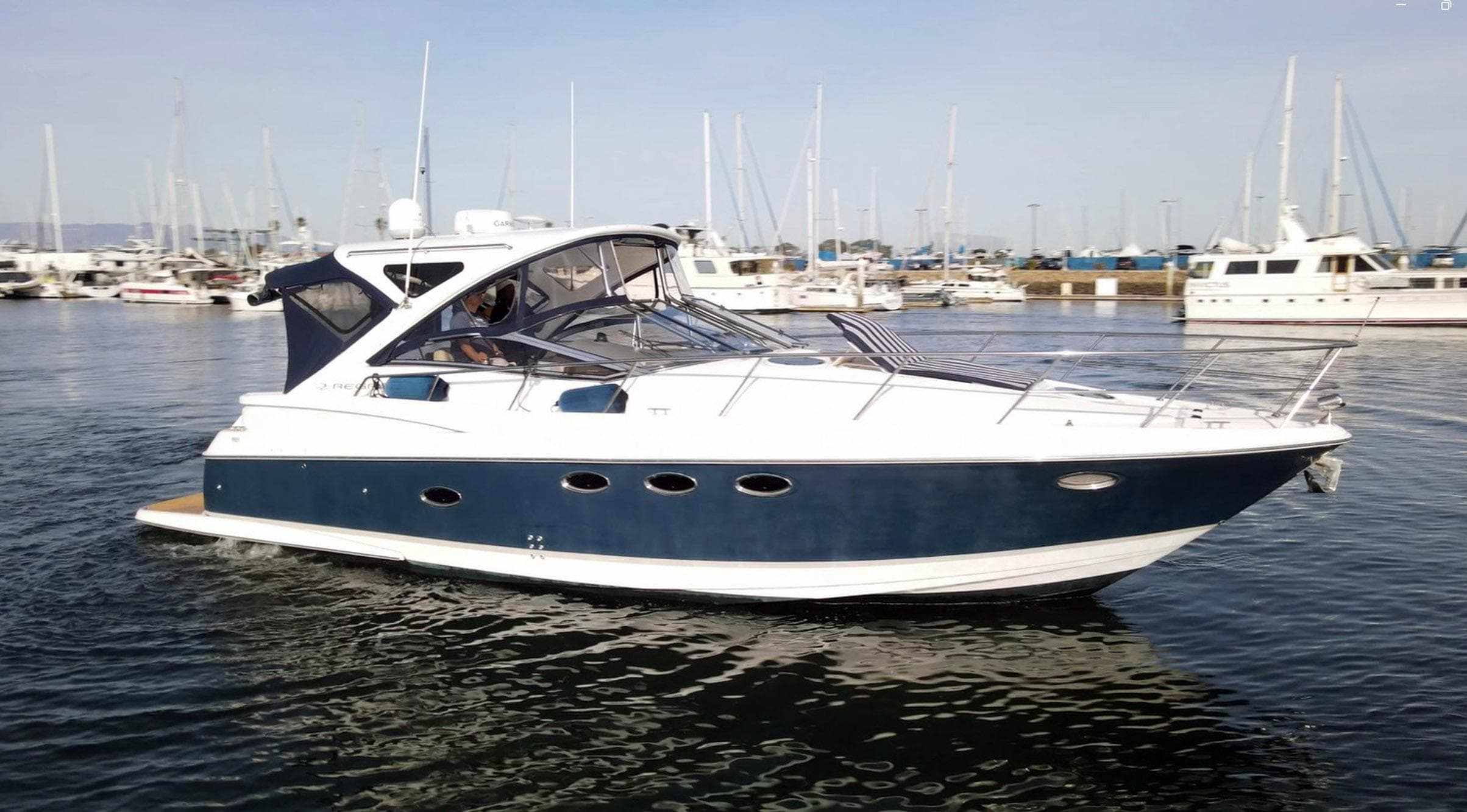 2008 Regal Commodore 4060 yacht cruising in a marina with other boats in the background.