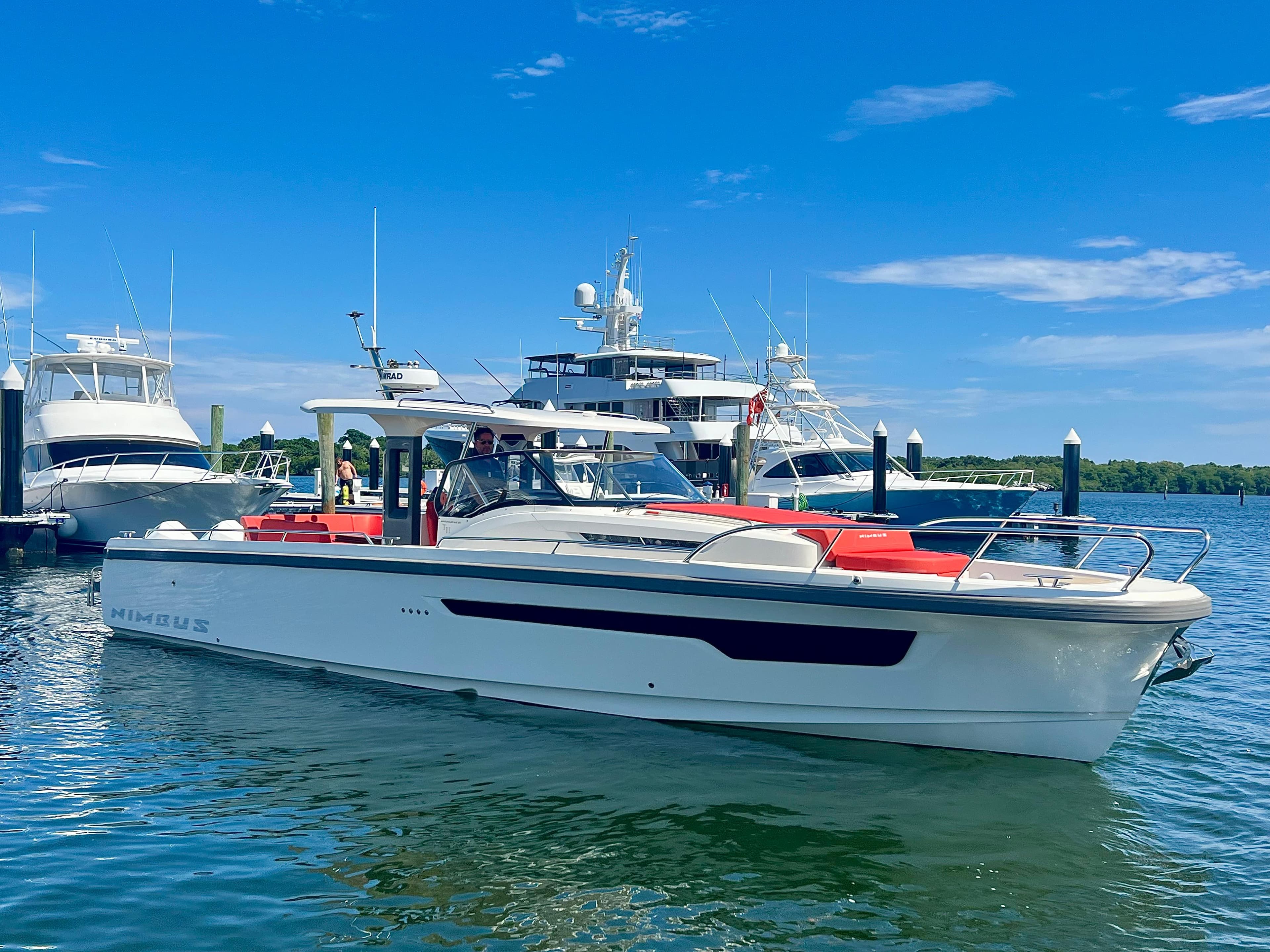 2022 Nimbus T11 #98 TRADE! boat docked in marina under clear blue sky.