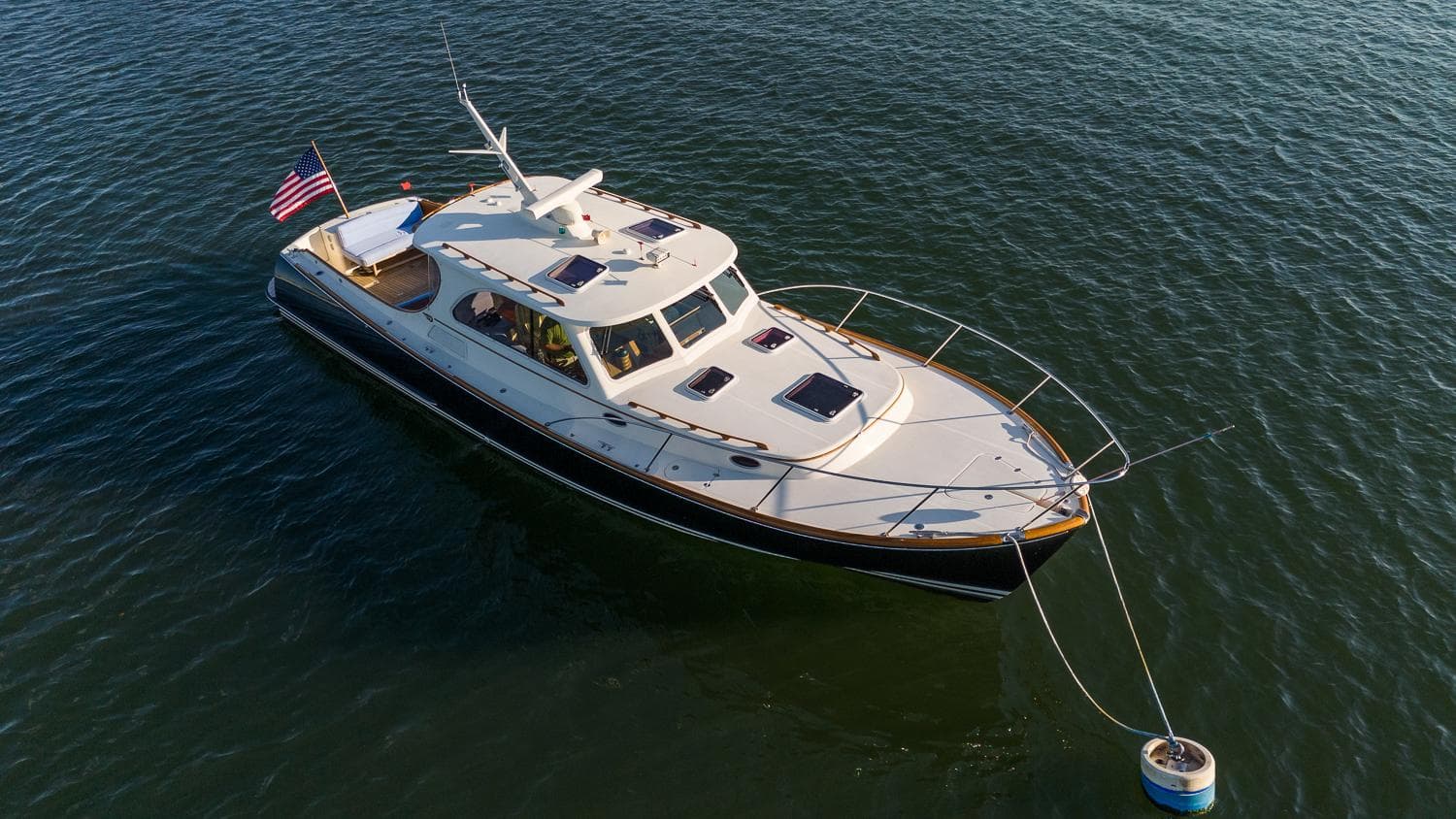 2005 Hinckley Talaria 40 yacht anchored on calm water with American flag.