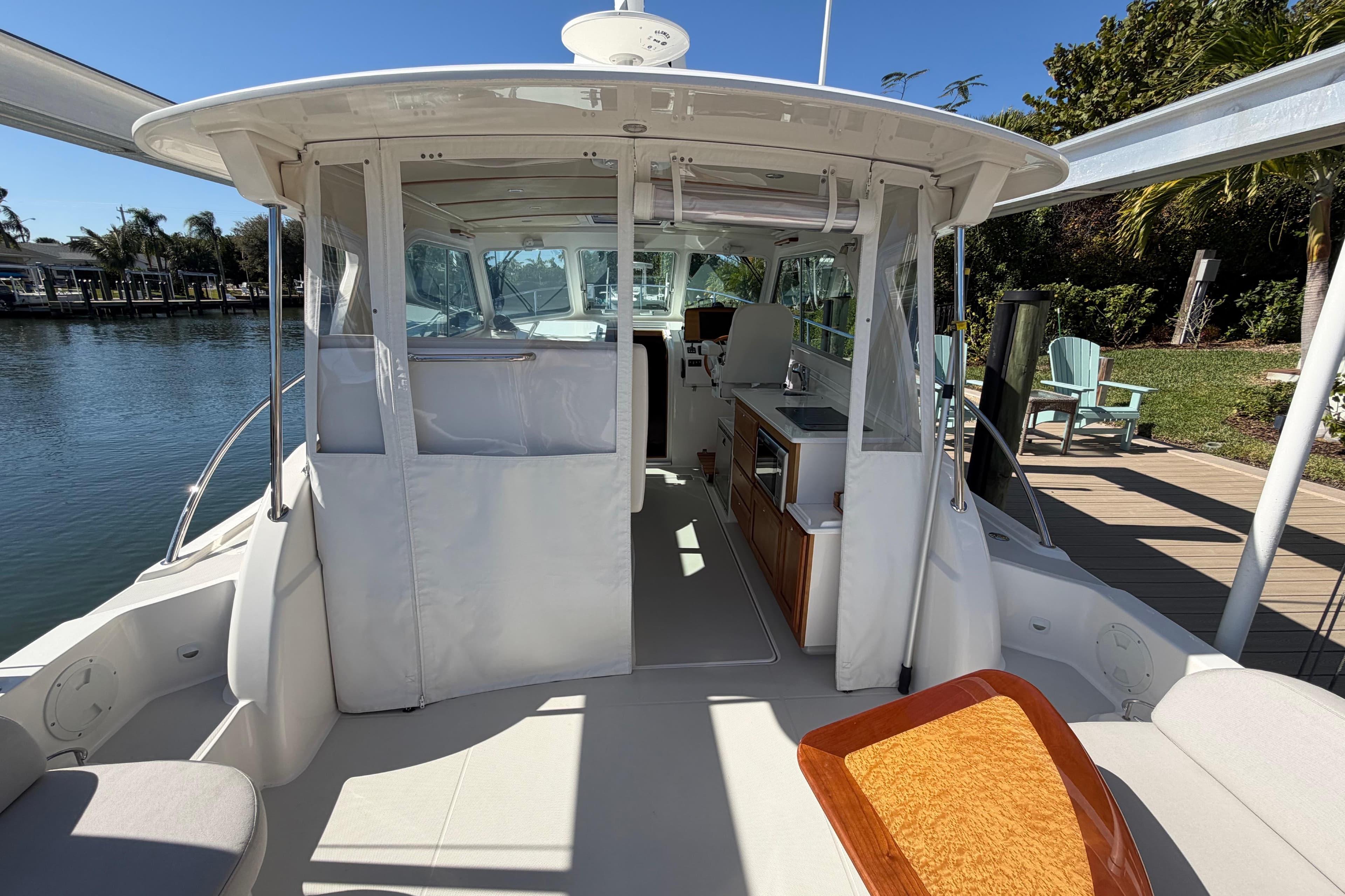 2023 Back Cove 340 boat interior with seating and kitchen area, docked by water.