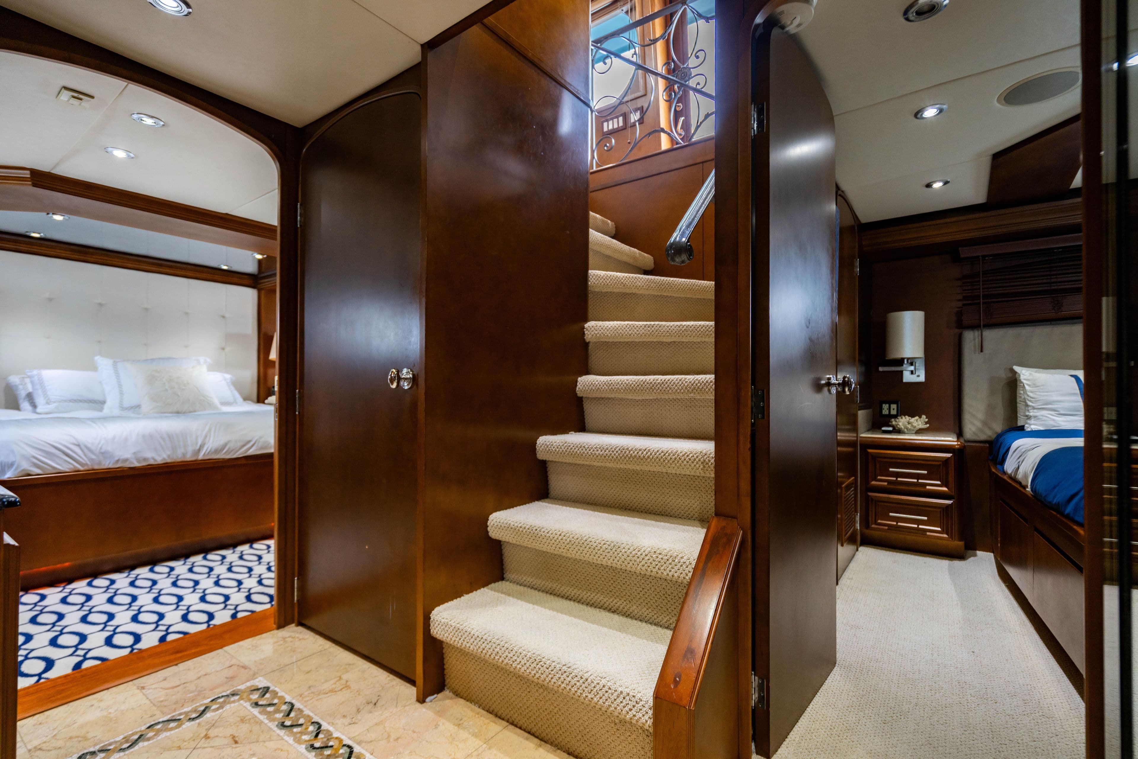 Luxurious interior of 2006 Broward Raised Pilothouse yacht with elegant staircase and bedrooms.