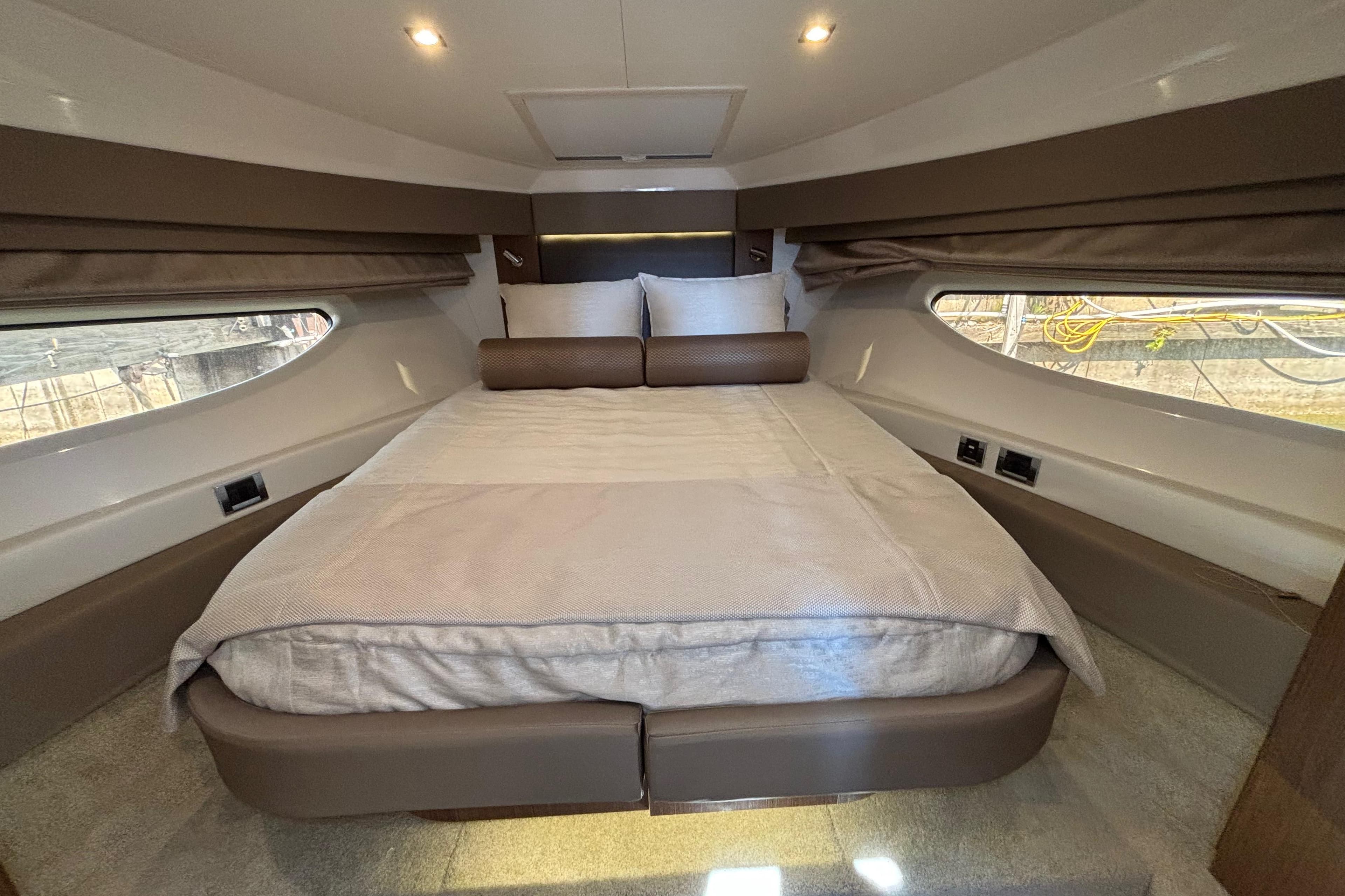 Luxurious cabin interior of 2018 Sea Ray Sundancer 460 yacht with cozy bed and ambient lighting.