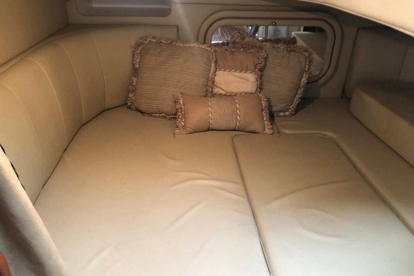 2006 Rinker 342 Express Cruiser cabin interior with beige cushions and pillows.