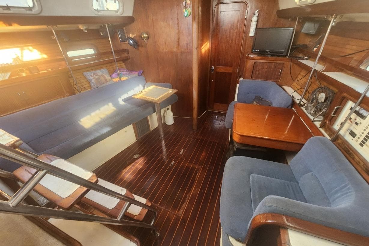 Interior of 1993 Catalina Morgan 381 sailboat with wooden furnishings and blue seating.