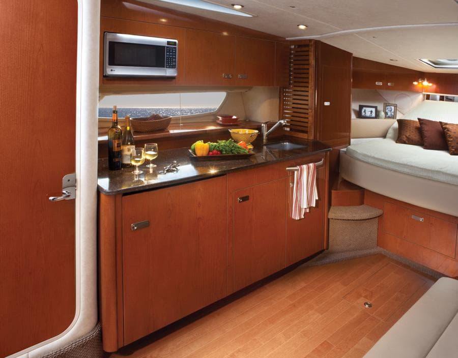 Manufacturer Provided Image: Luxurious interior of 2013 Sea Ray 370 Sundancer yacht with kitchen and cozy bedroom.