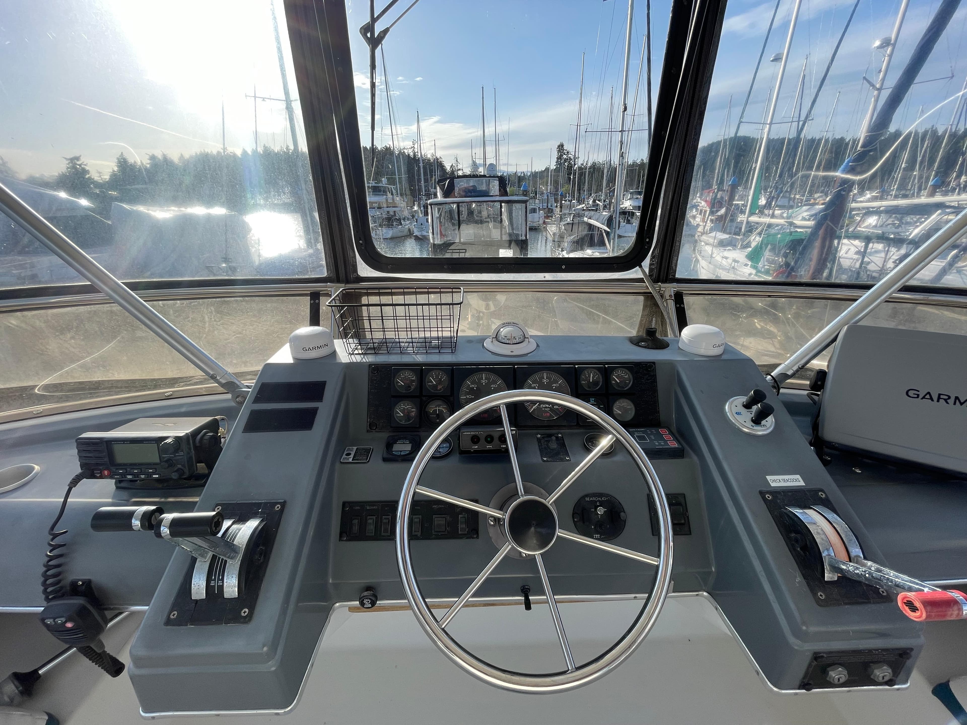 Cockpit view of a 1991 Bayliner 4387 yacht with steering wheel and navigation controls.