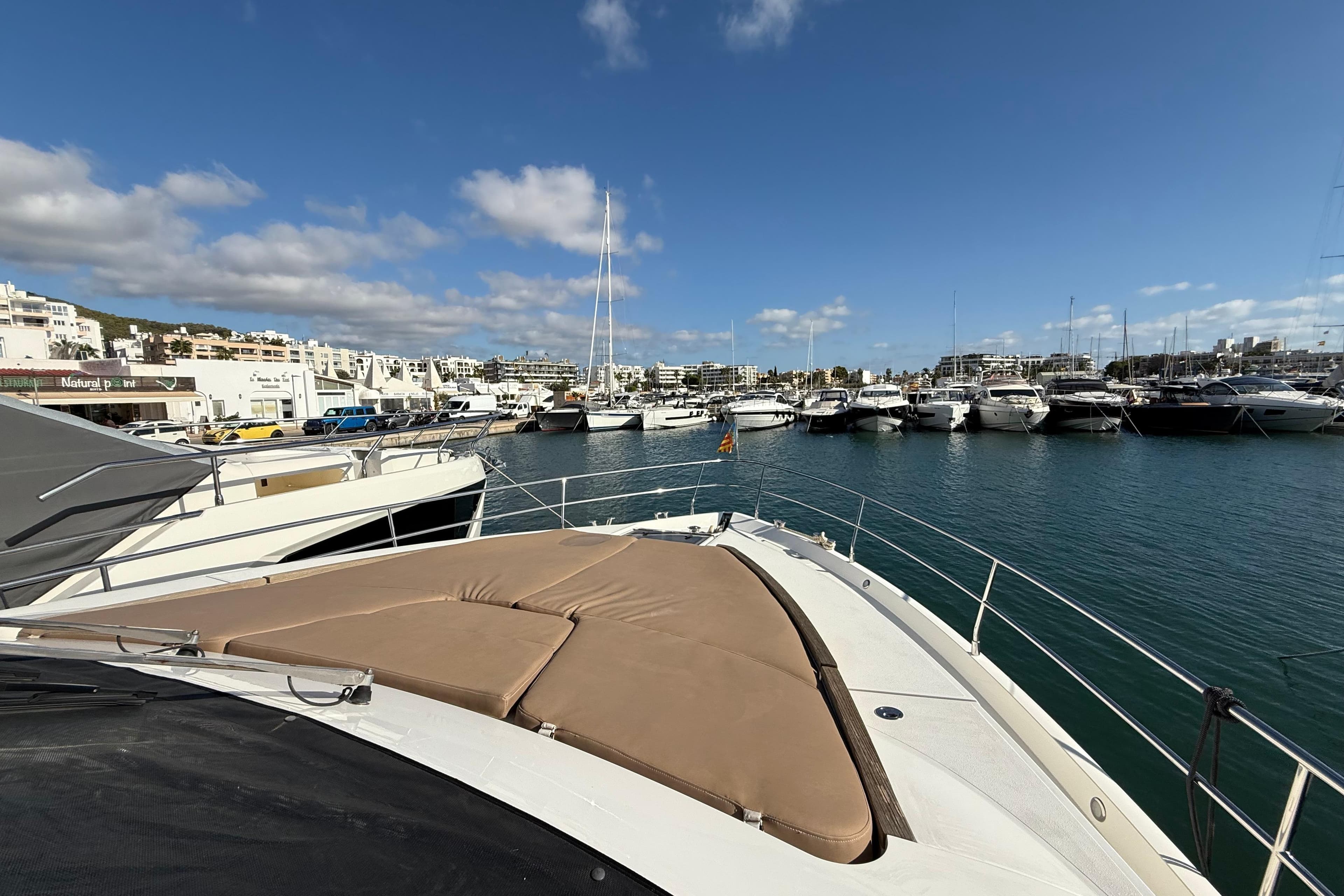 Luxury yacht Fairline Squadron 58, 2012, docked in a sunny marina with clear skies.