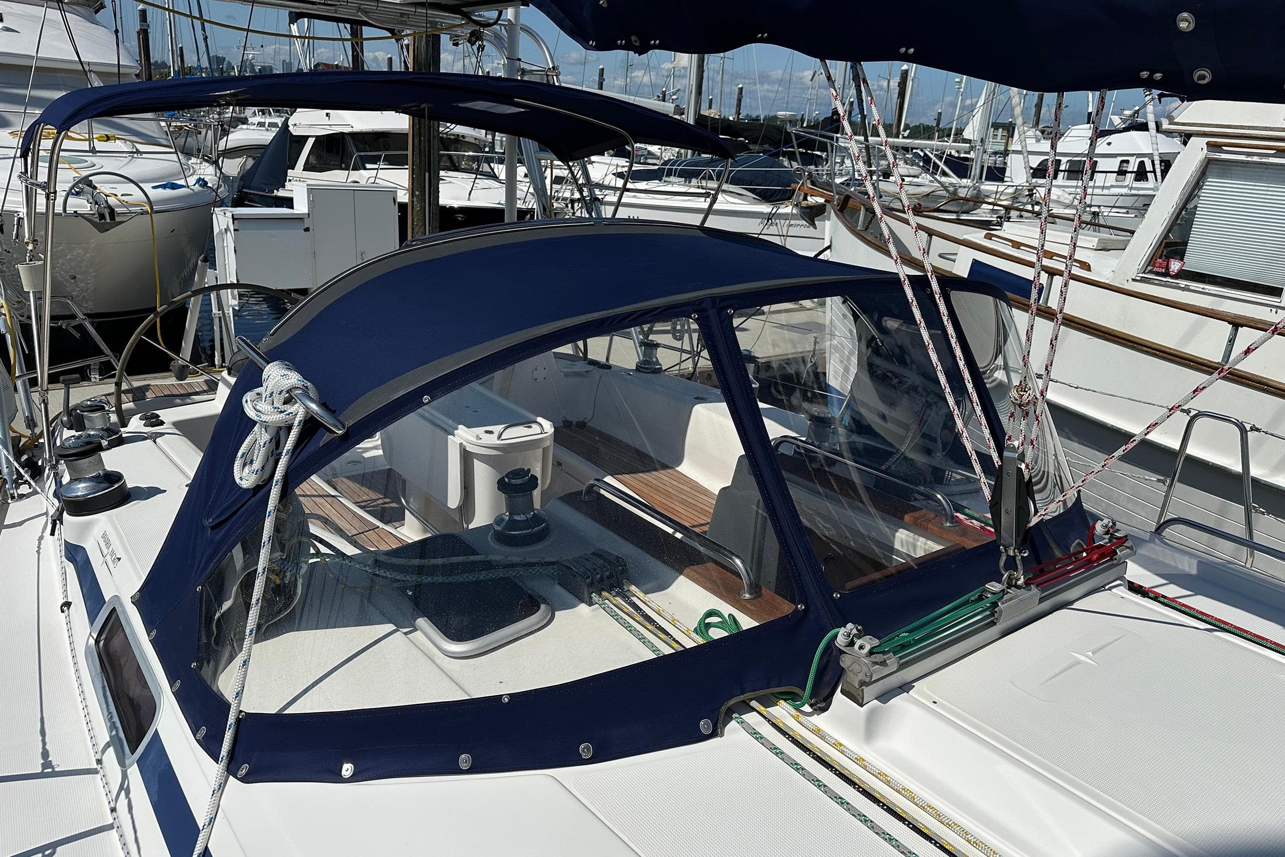 Sailboat Bavaria 44 (2003) with blue canopy docked at marina.