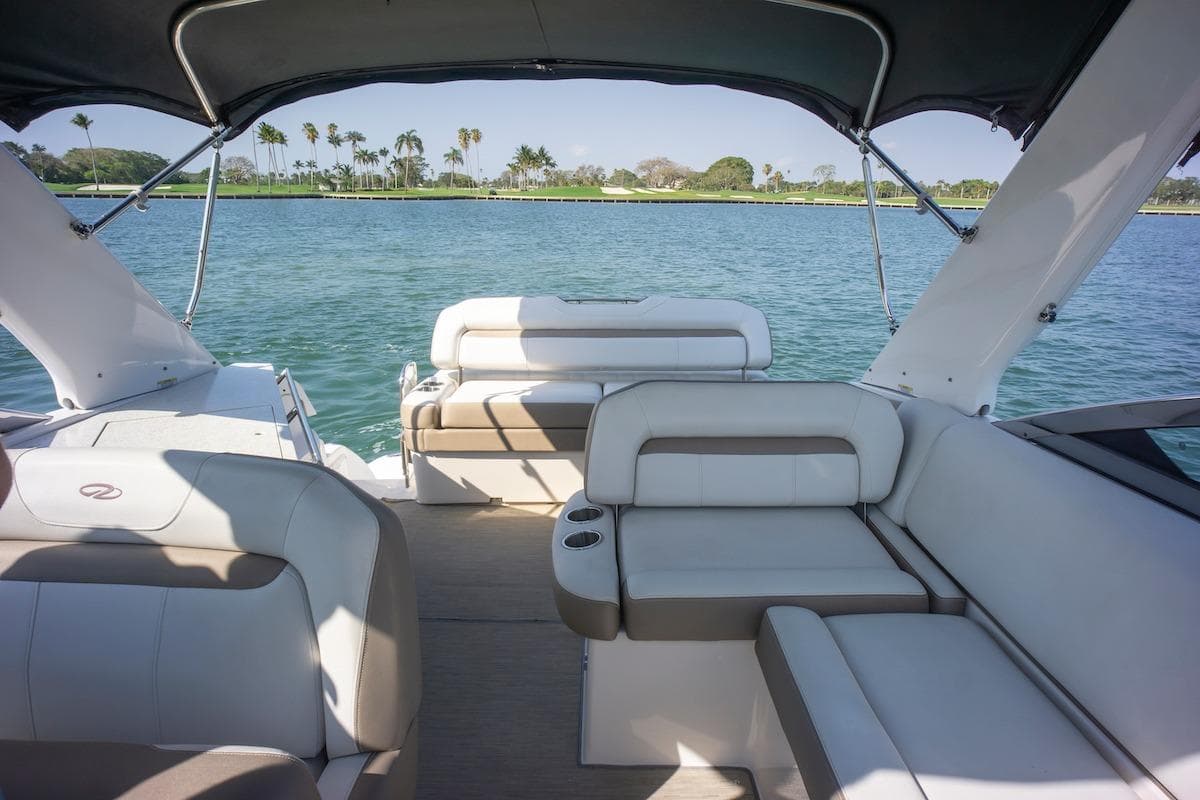 2016 Regal 32 Express boat interior with seating, overlooking calm water and palm trees.