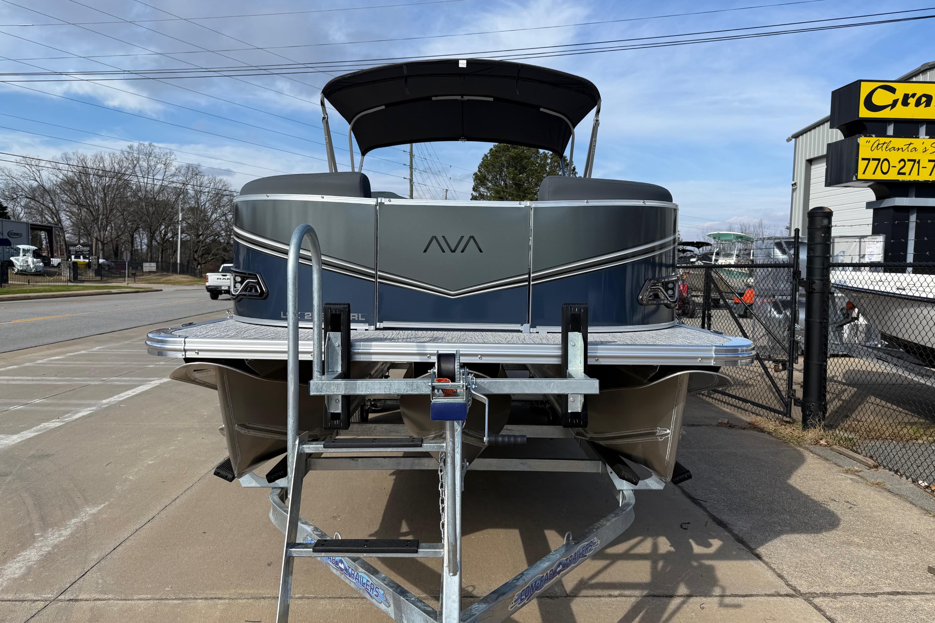 2026 Avalon LSZ Versatile Rear Lounger pontoon boat on trailer, parked outdoors.