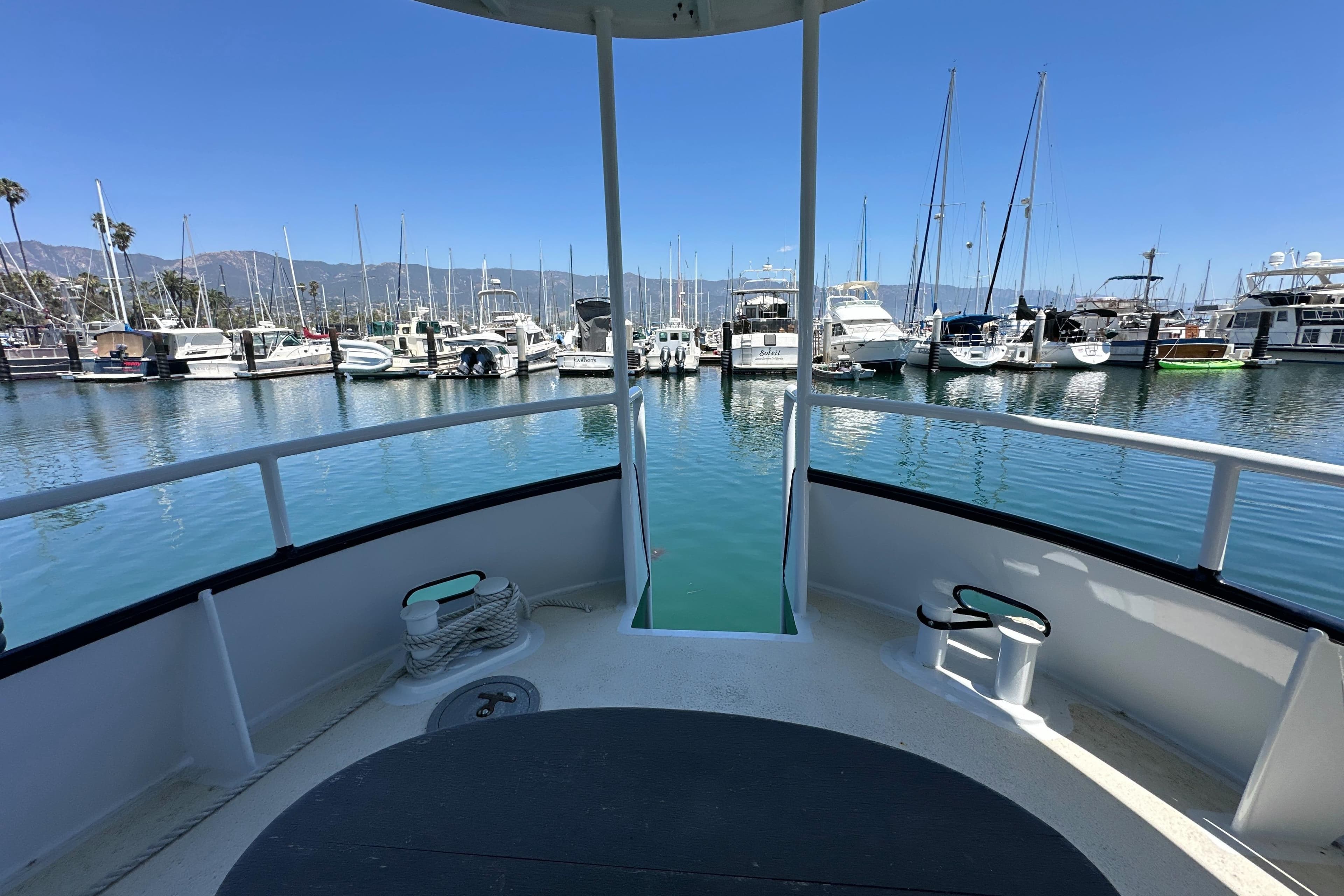 View from the deck of a 2012 Custom Pacific Northwest 43 yacht in a marina.