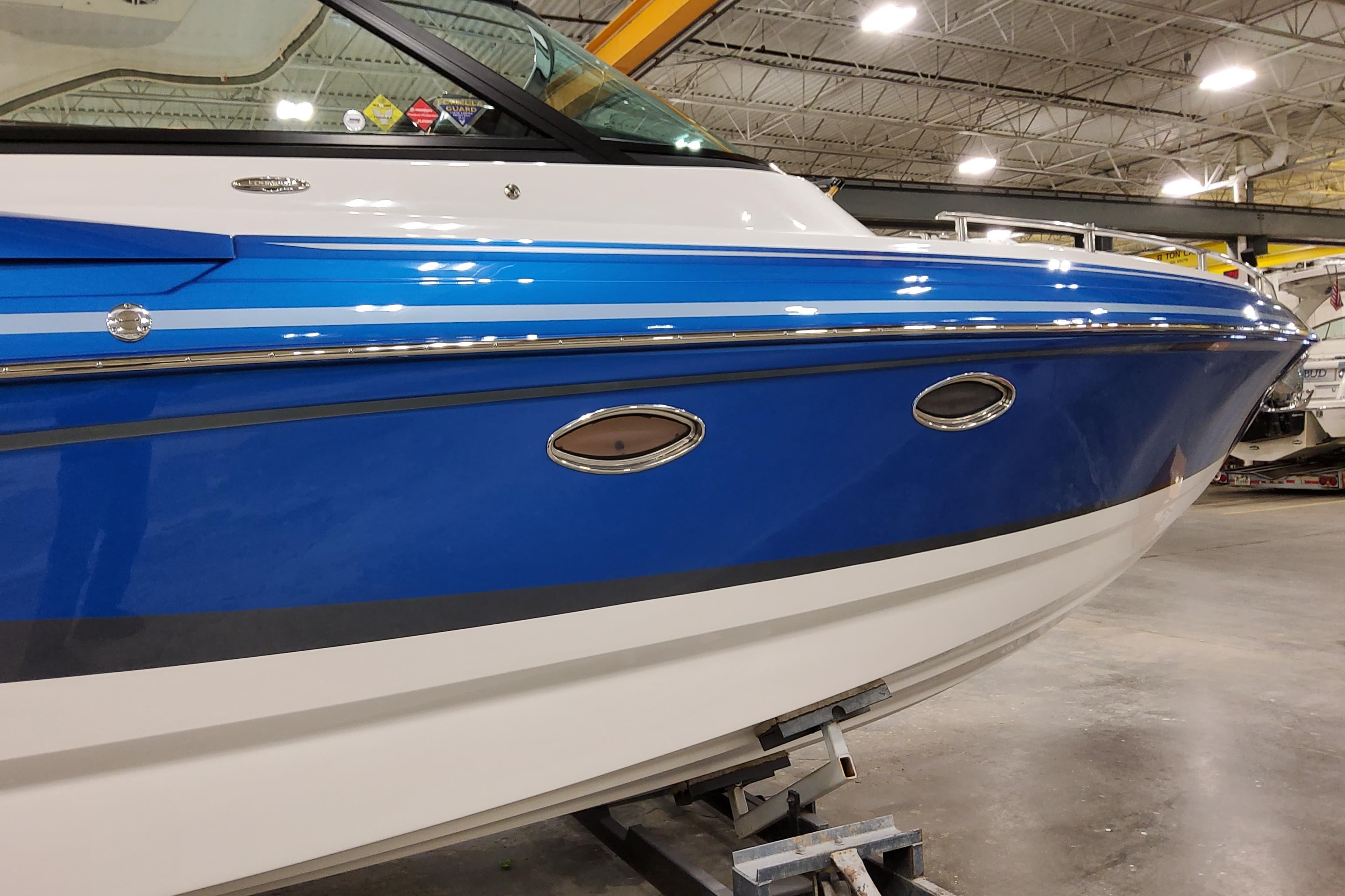 2027 Formula 330 Crossover Bowrider OB in a showroom, featuring sleek blue and white design.