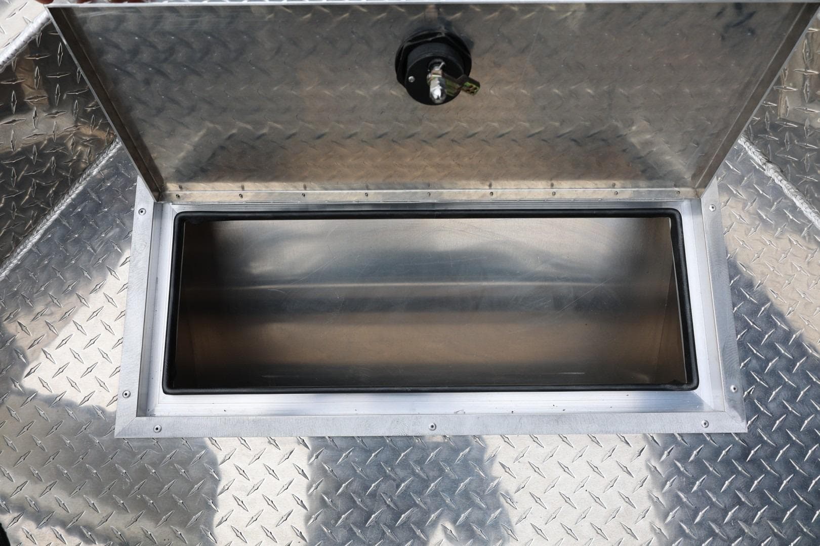 Open storage compartment on 2026 Thunder Jet 200 Luxor boat with diamond plate flooring.
