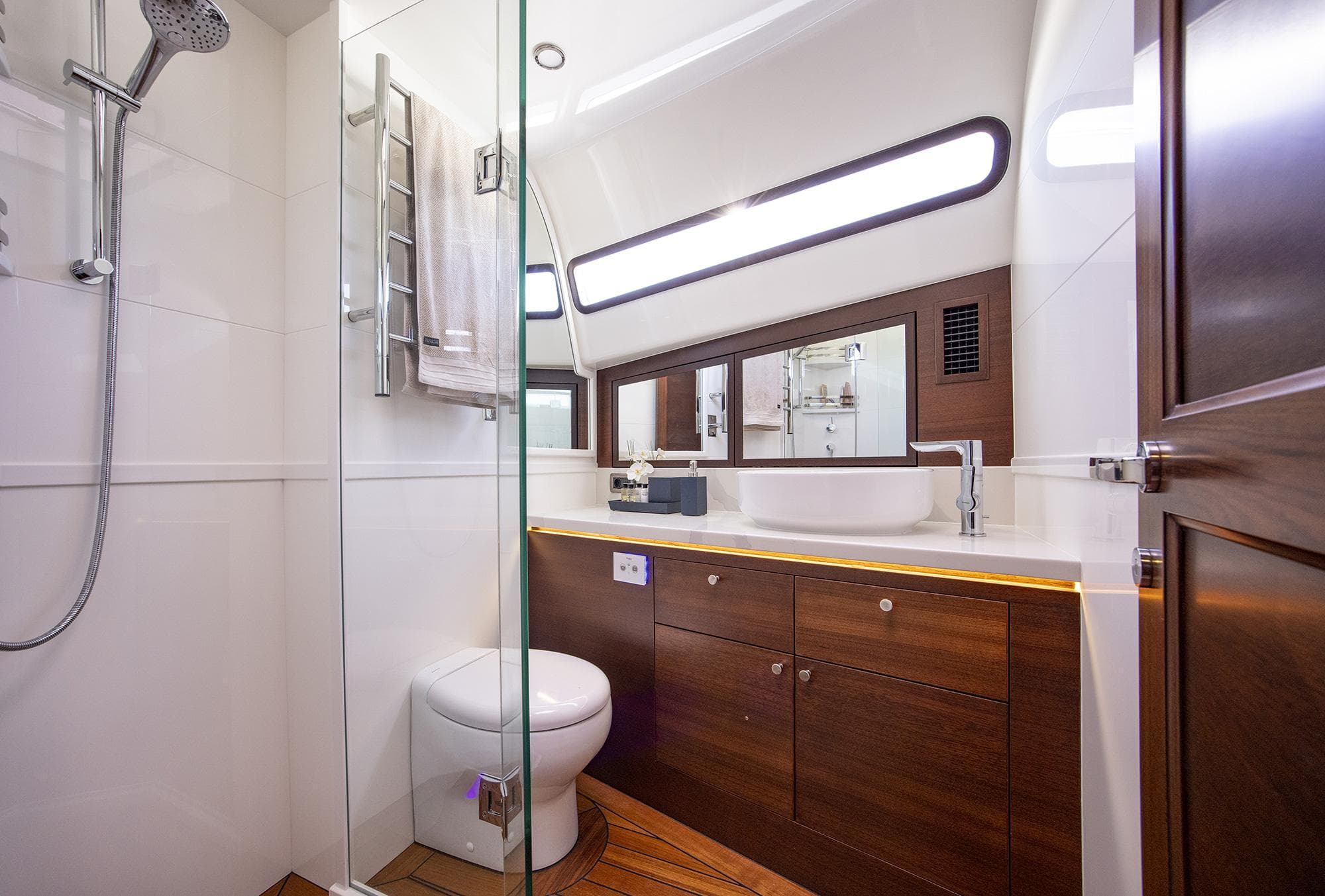 Luxurious bathroom in 2026 Grand Banks GB 85 yacht with modern fixtures and wooden cabinetry.