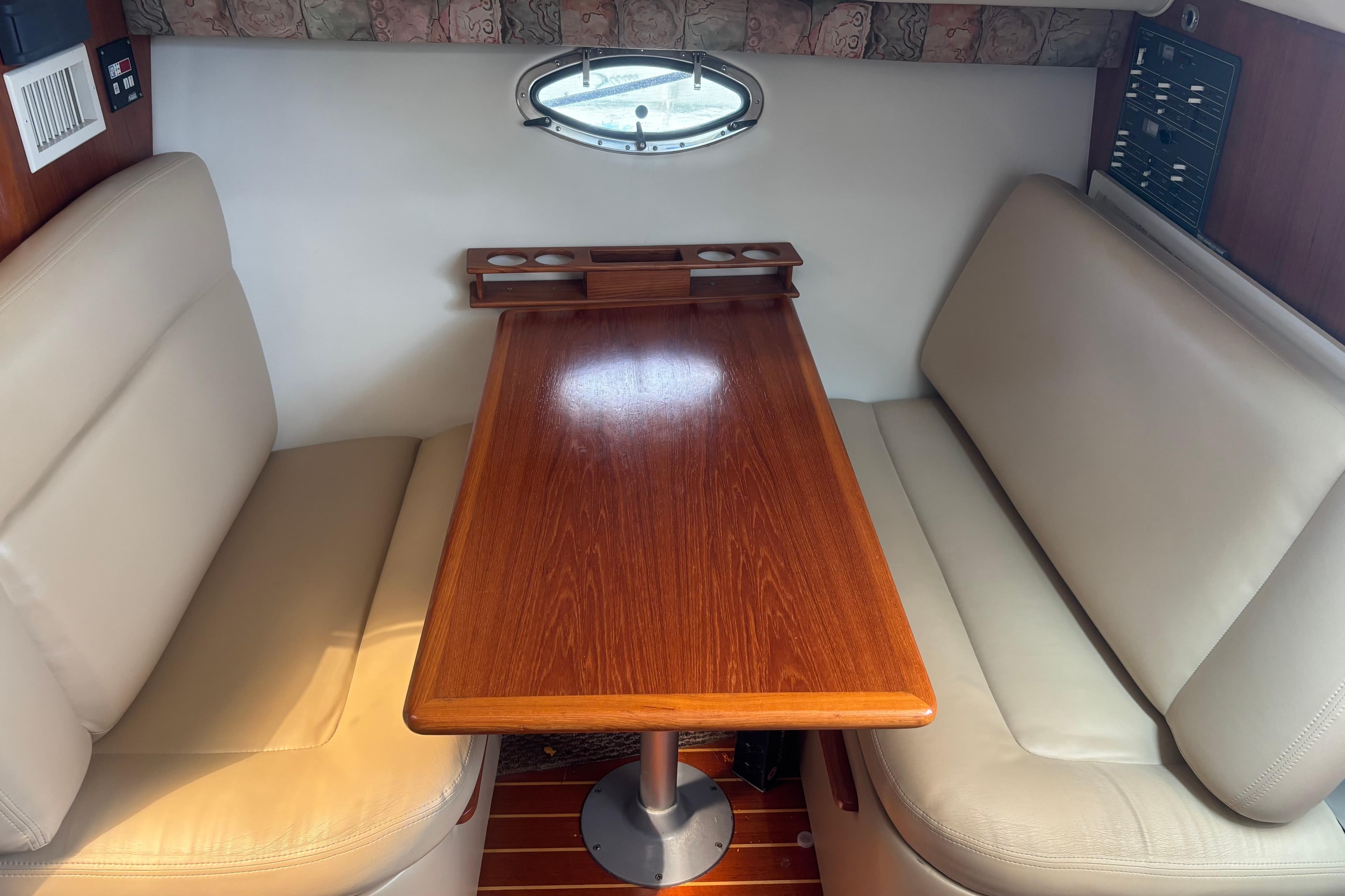 1998 Tiara Yachts 2900 Coronet interior with wooden table and beige seating.
