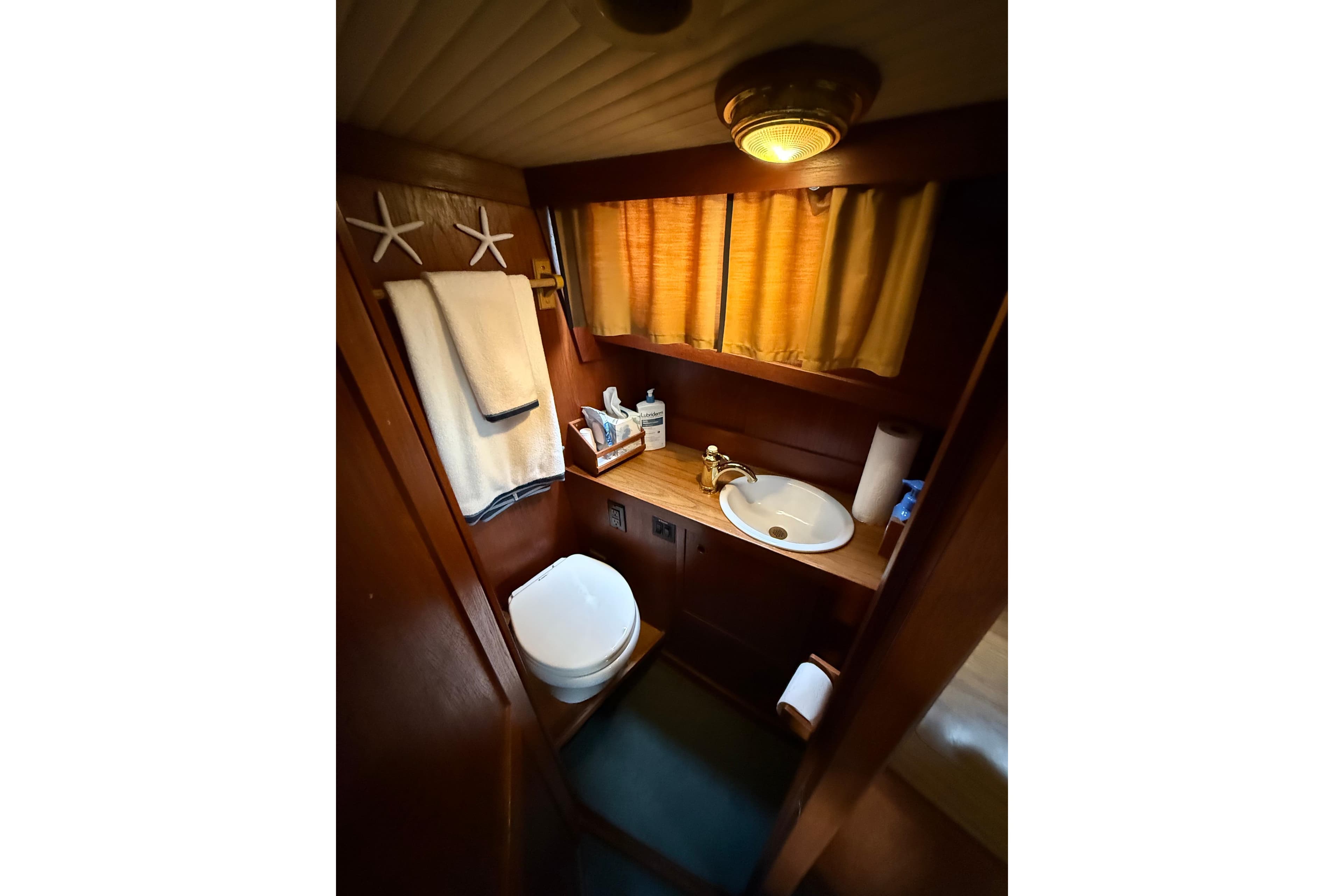 Cozy 1980 Nauticat Pilothouse bathroom with wooden decor and nautical accents.
