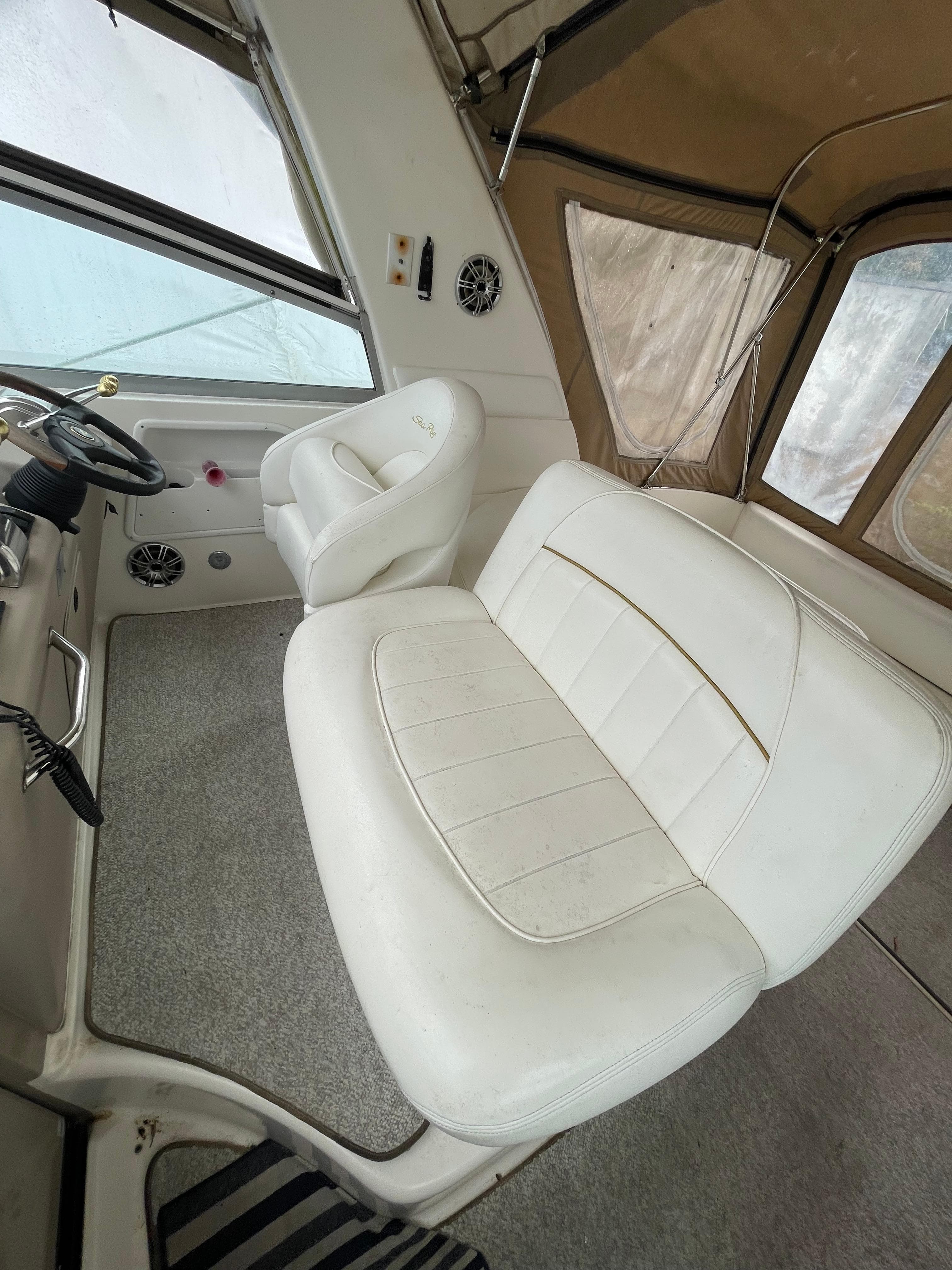 2001 Sea Ray 310 Sundancer interior with white seating and helm, showcasing luxury design.