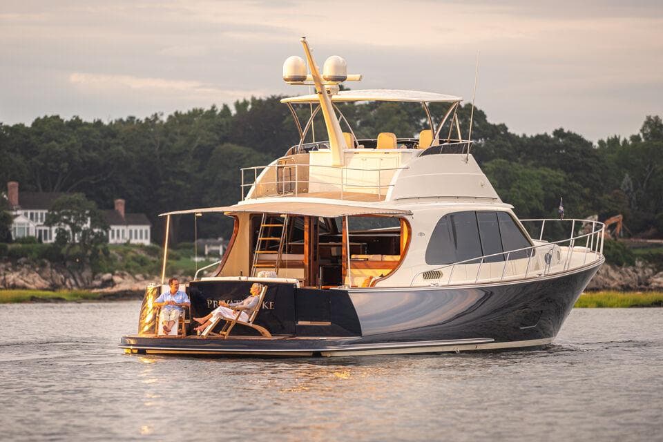 2026 Palm Beach Motor Yachts PB70 cruising on serene waters at sunset.
