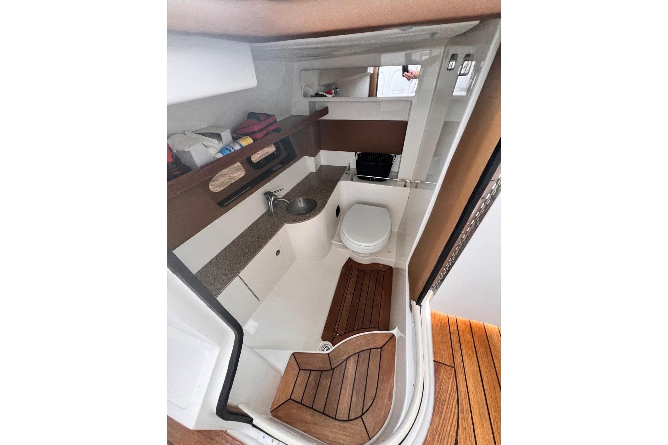 2014 Sea Ray SLX 350 boat interior with sink, toilet, and wooden flooring.