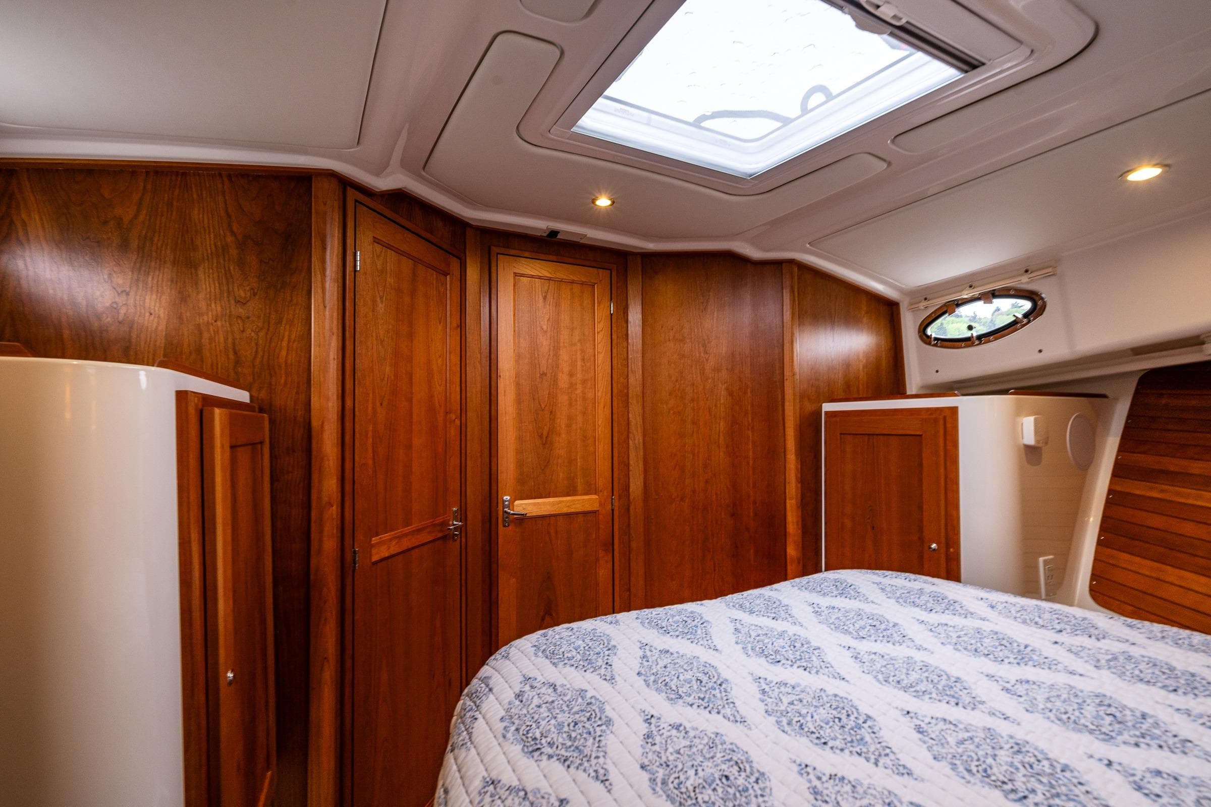 Luxurious cabin interior of 2025 Back Cove 39O yacht with wooden finishes and skylight.