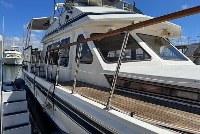 1985 Spindrift Trawler docked at marina, showcasing classic design and spacious deck.