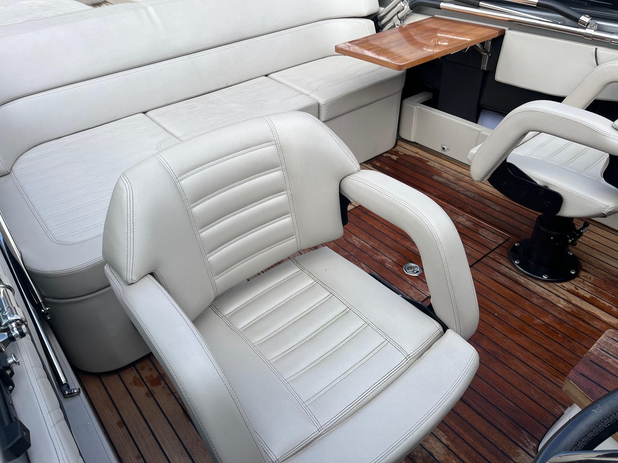 2020 Cranchi E26 Classic boat interior with white leather seats and wooden flooring.