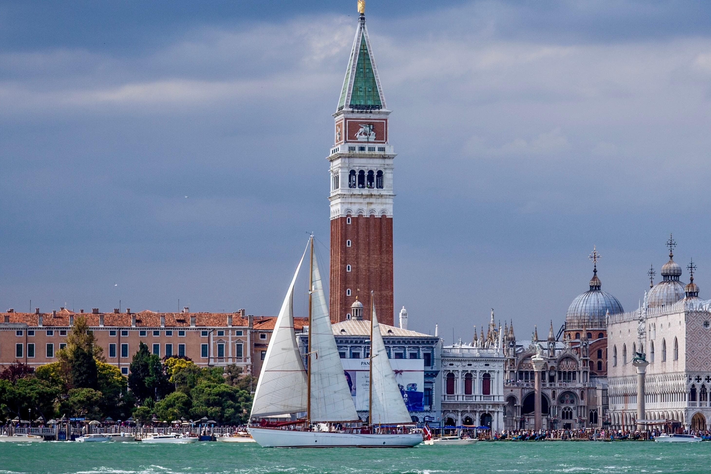 Vintage 1950 MOLLICH Sailing boat in Venice with historic architecture backdrop.