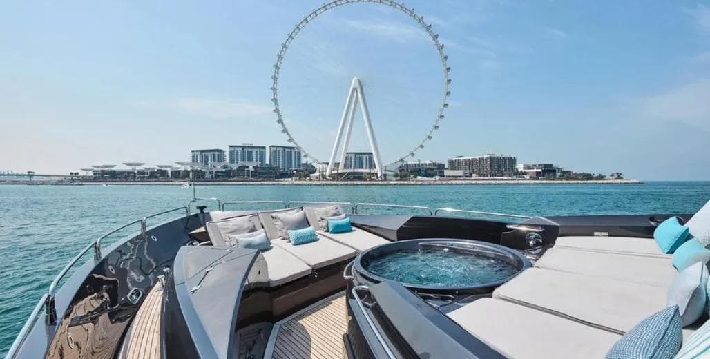 Luxurious 2006 Sunseeker Predator 108 yacht with jacuzzi, city skyline, and Ferris wheel view.