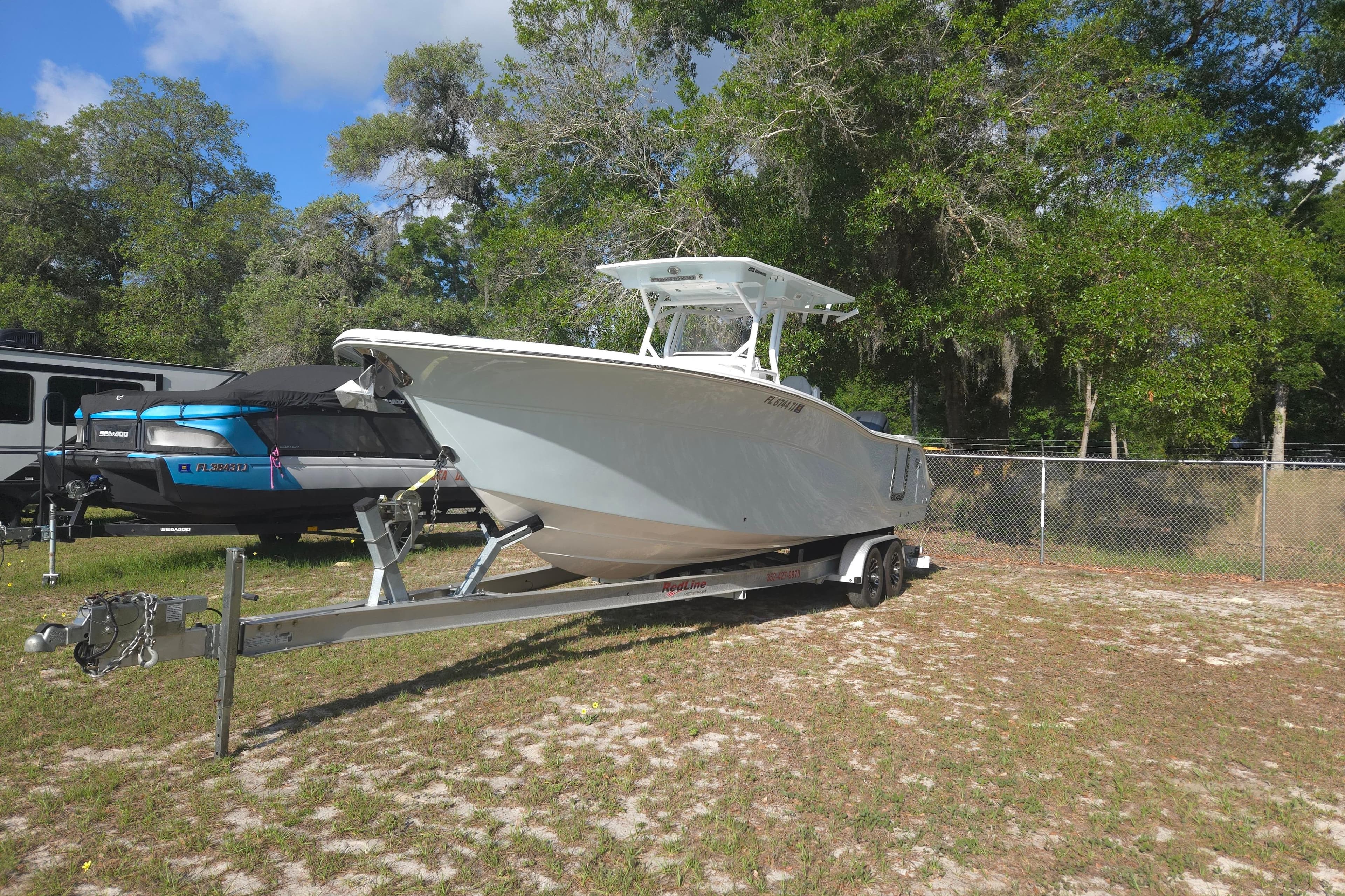 2023 Sea Fox 288 Commander boat on trailer, parked outdoors near trees.