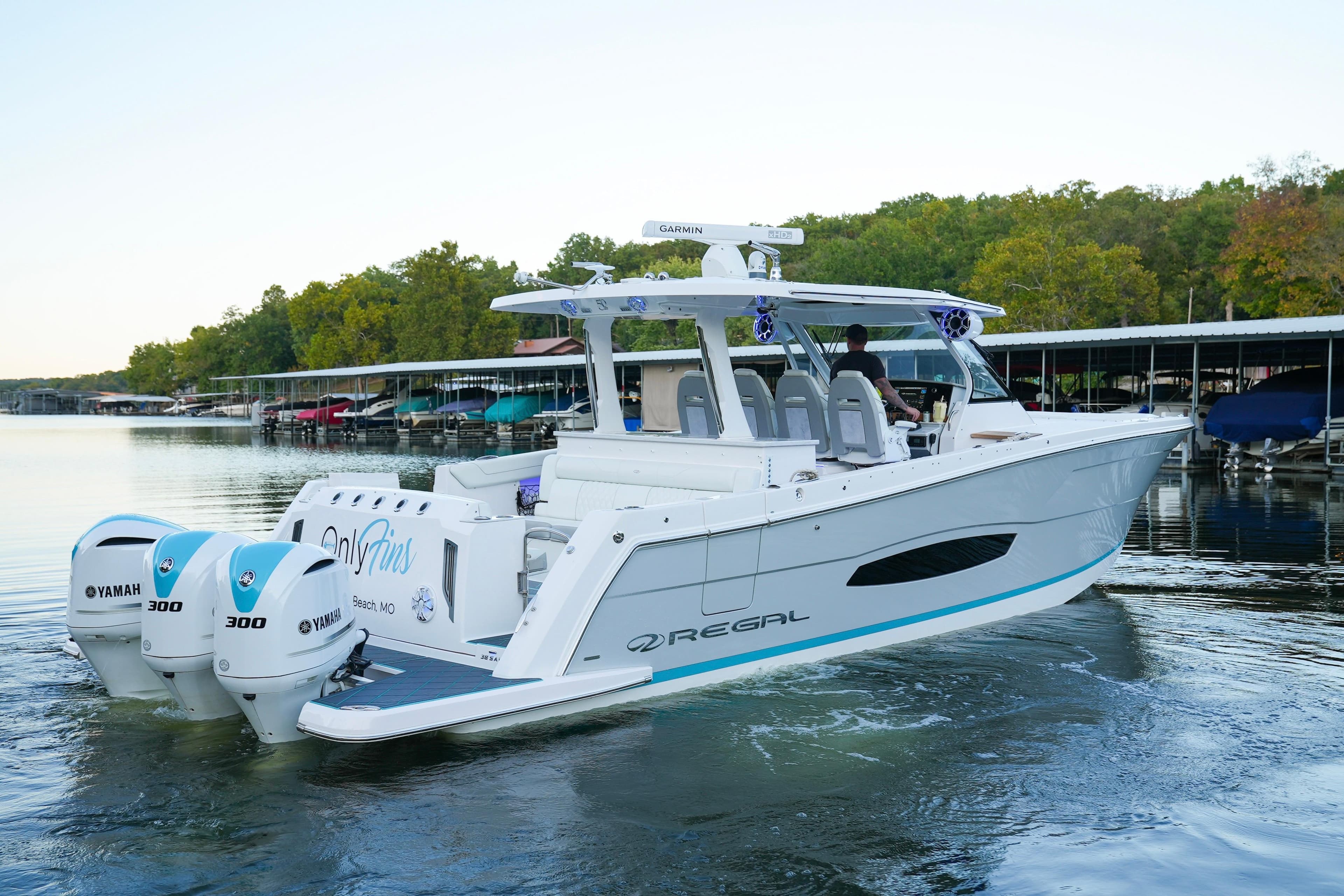 2021 Regal 38 SAV boat with twin Yamaha 300 engines on a calm lake.