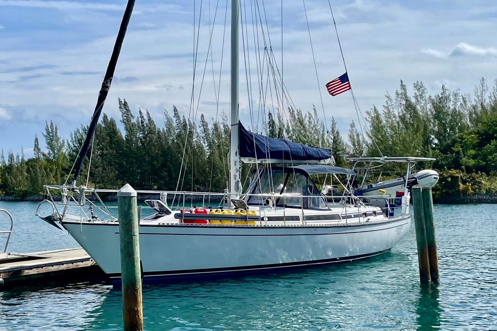 1986 Gulfstar HIRSCH sailboat docked in serene marina with American flag.