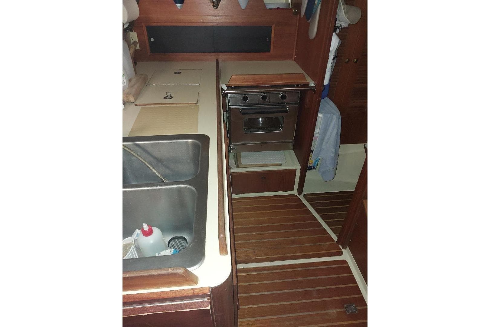 1985 Pearson Yachts 36-2 galley with stove, sink, and wooden flooring.