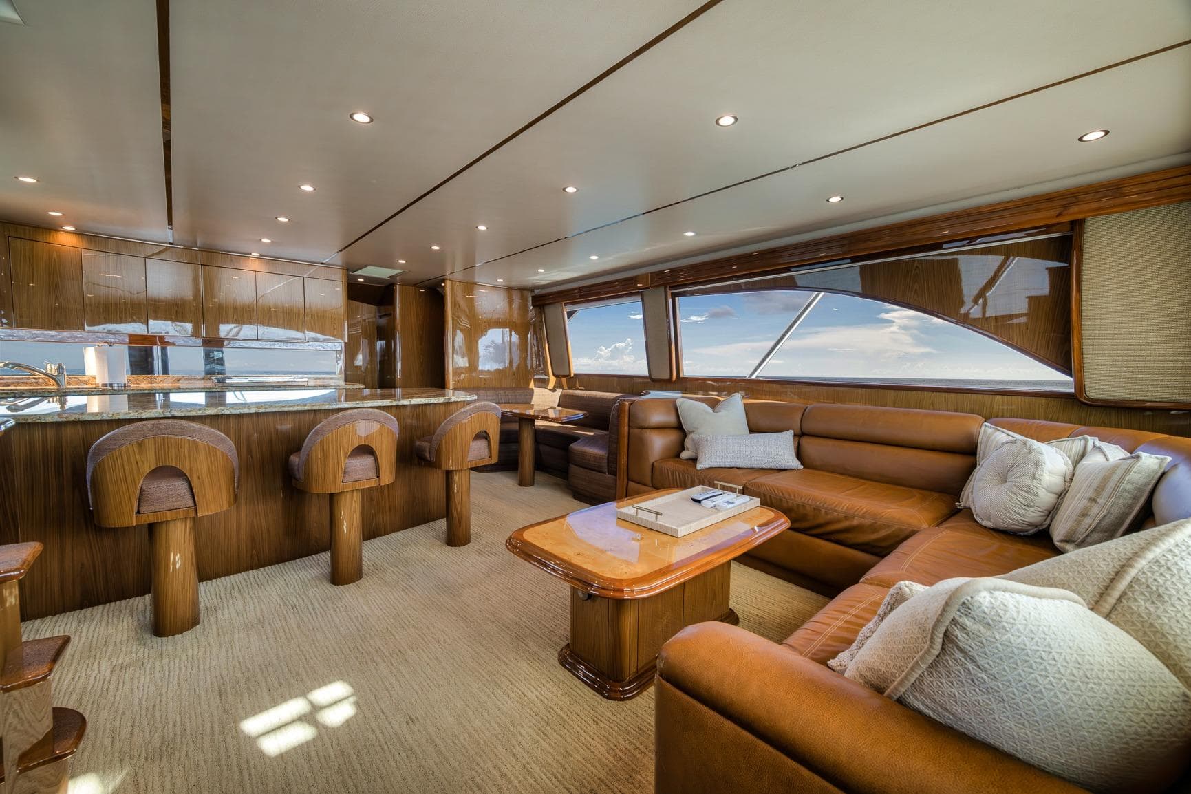 Luxurious interior of 2012 Viking 70 Enclosed Bridge yacht with leather seating and bar stools.