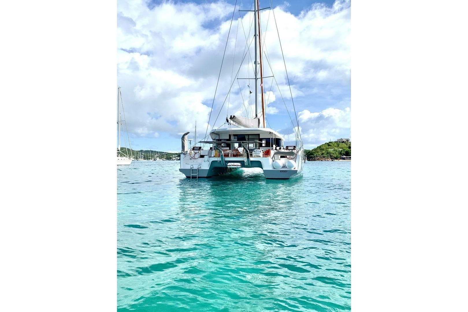 2023 Excess 14 catamaran sailing on clear turquoise waters under a bright blue sky.