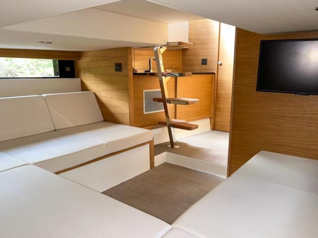Luxurious interior of 2023 De Antonio Yachts D42 Open with modern seating and TV.