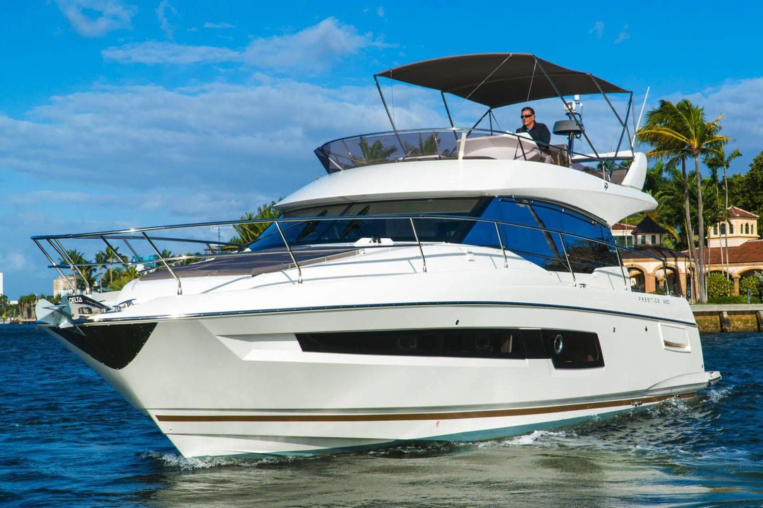 2020 Prestige 460 yacht cruising on a sunny day with blue skies.