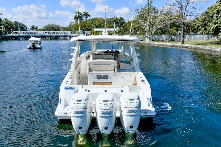 2019 Boston Whaler 350 Realm with triple outboard engines on a scenic waterway.