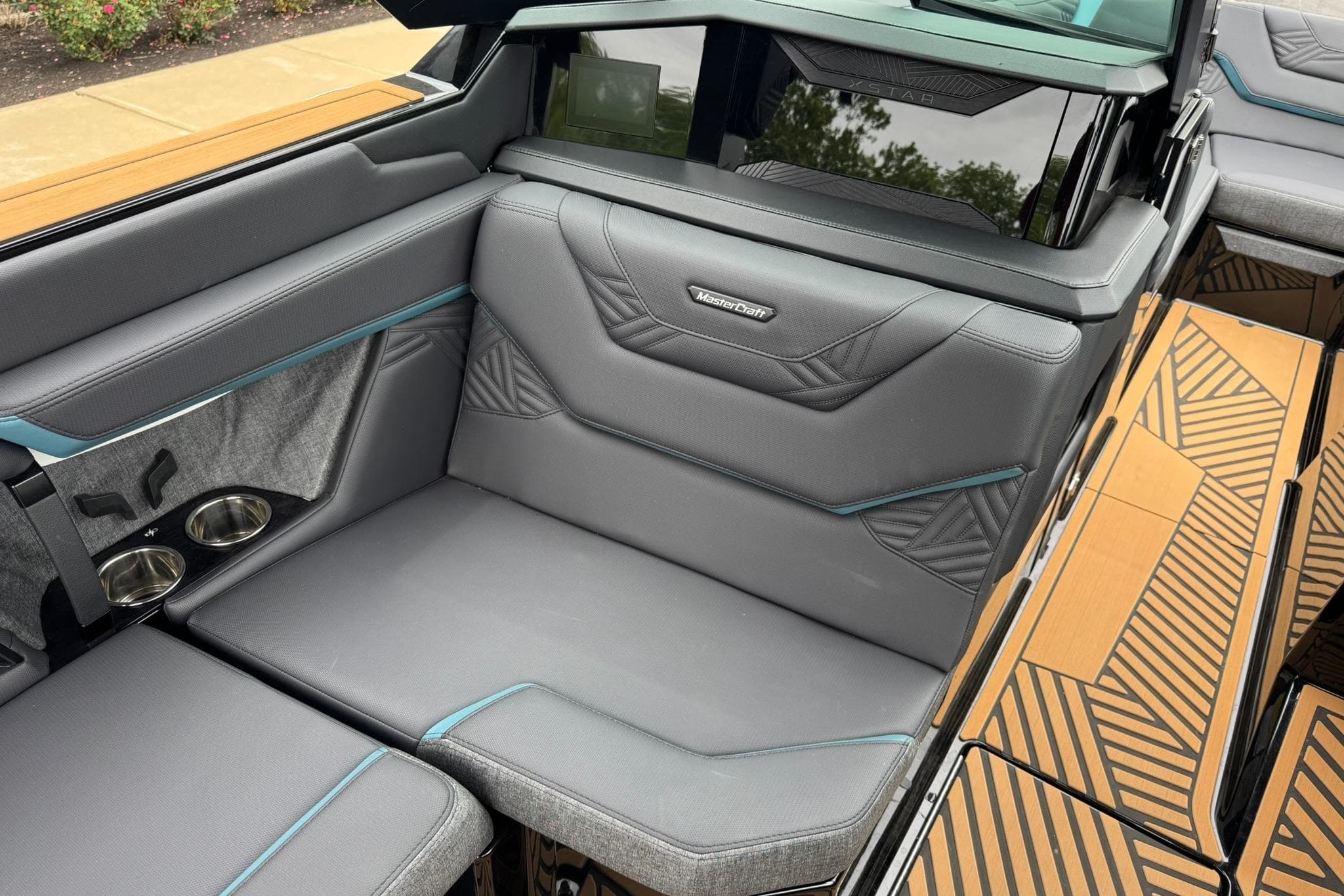 Luxurious interior of 2025 MasterCraft XStar 25 boat with gray seating and cup holders.