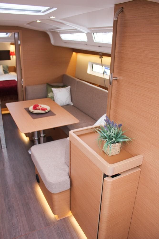 Interior of 2025 Jeanneau Sun Odyssey 440, featuring modern seating and dining area.