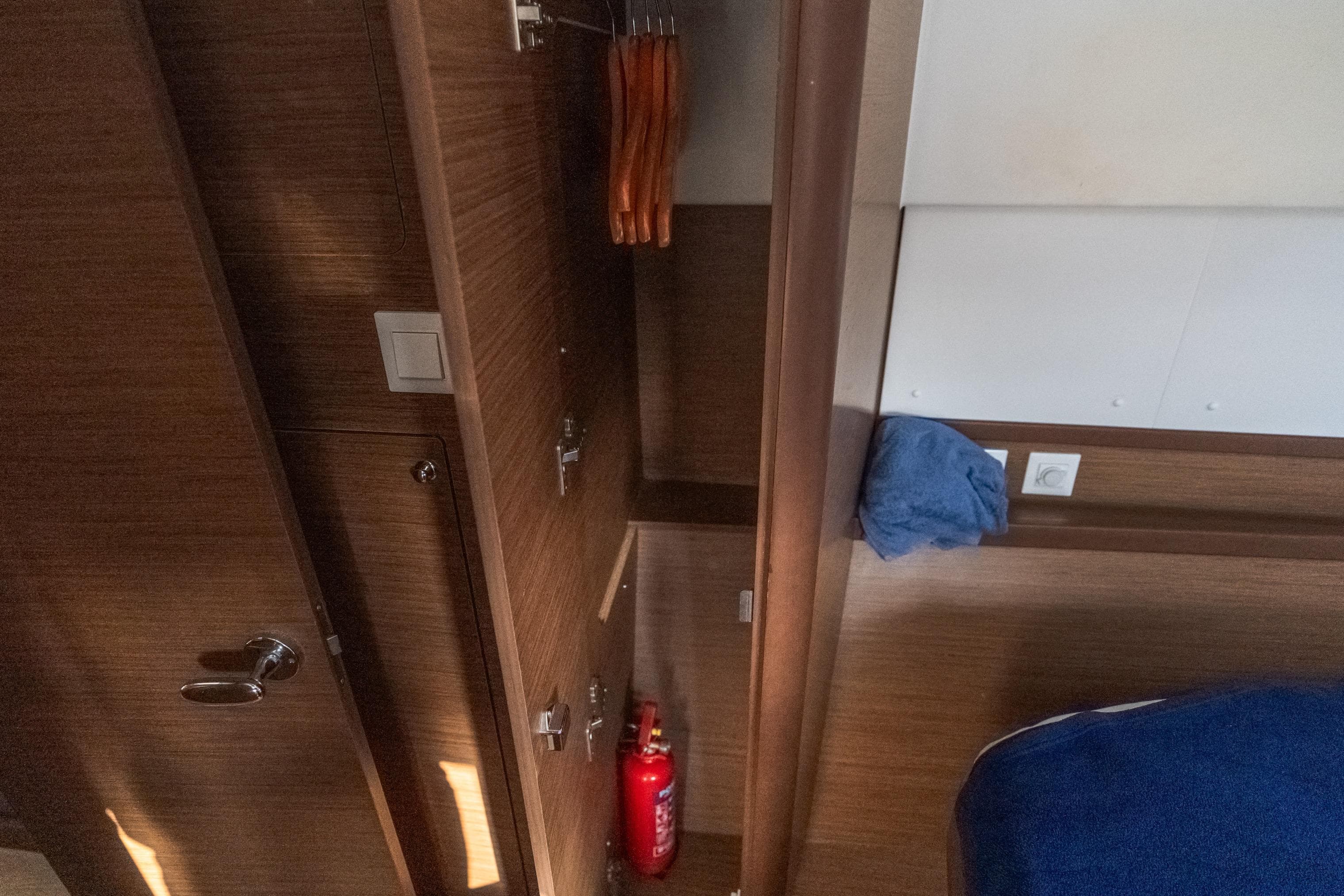 Interior of 2020 Lagoon 42 yacht with wooden closet and fire extinguisher.