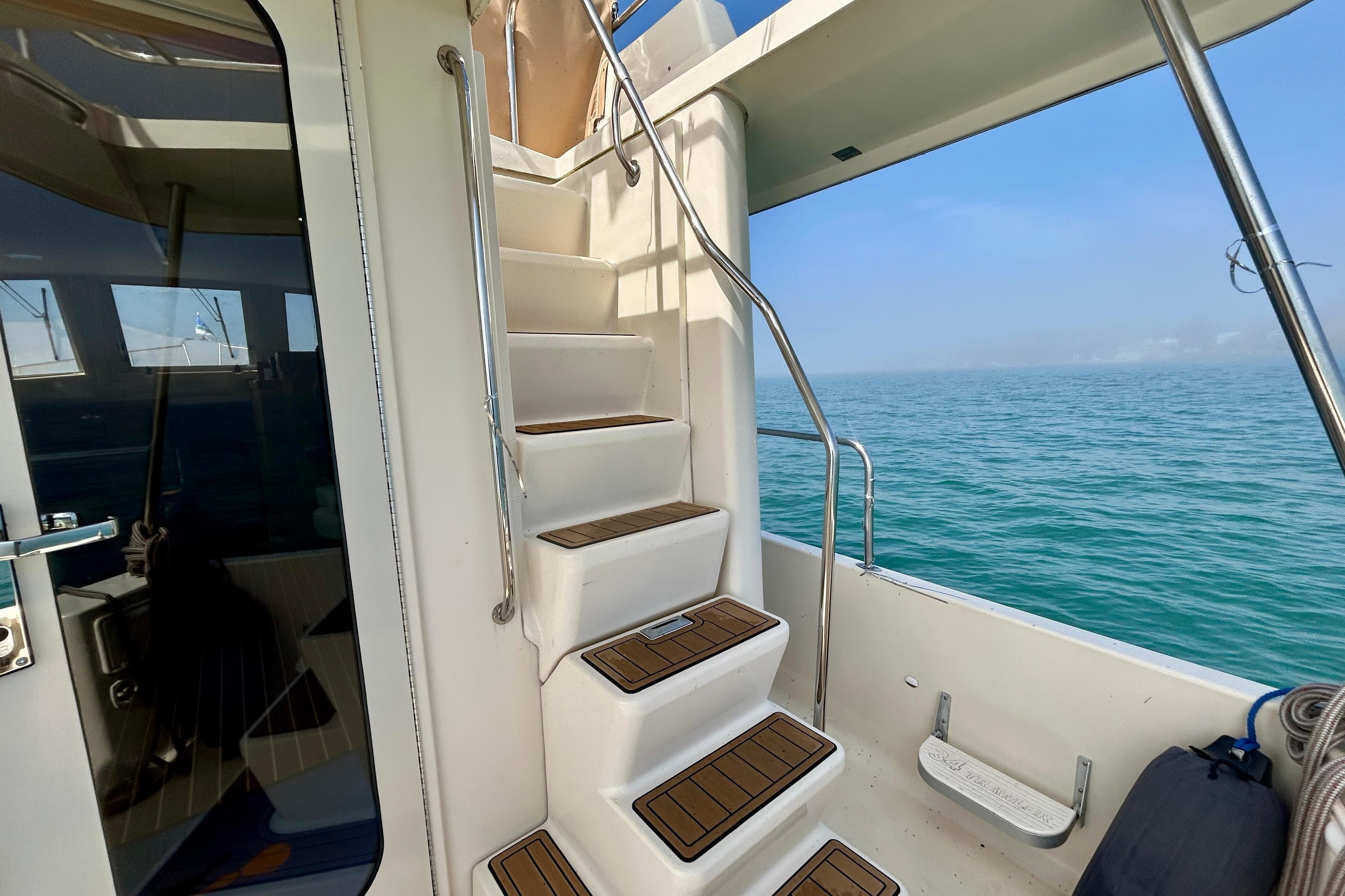 Staircase on 2006 Mainship 34 Trawler with ocean view in background.